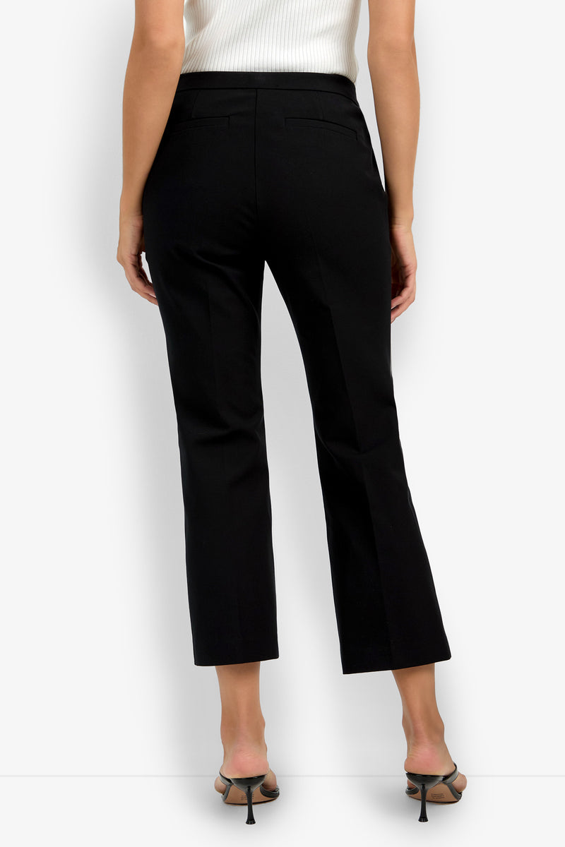A woman is shown from the back wearing black Lulu Pants, black heeled sandals, and a sleeveless white ribbed top.