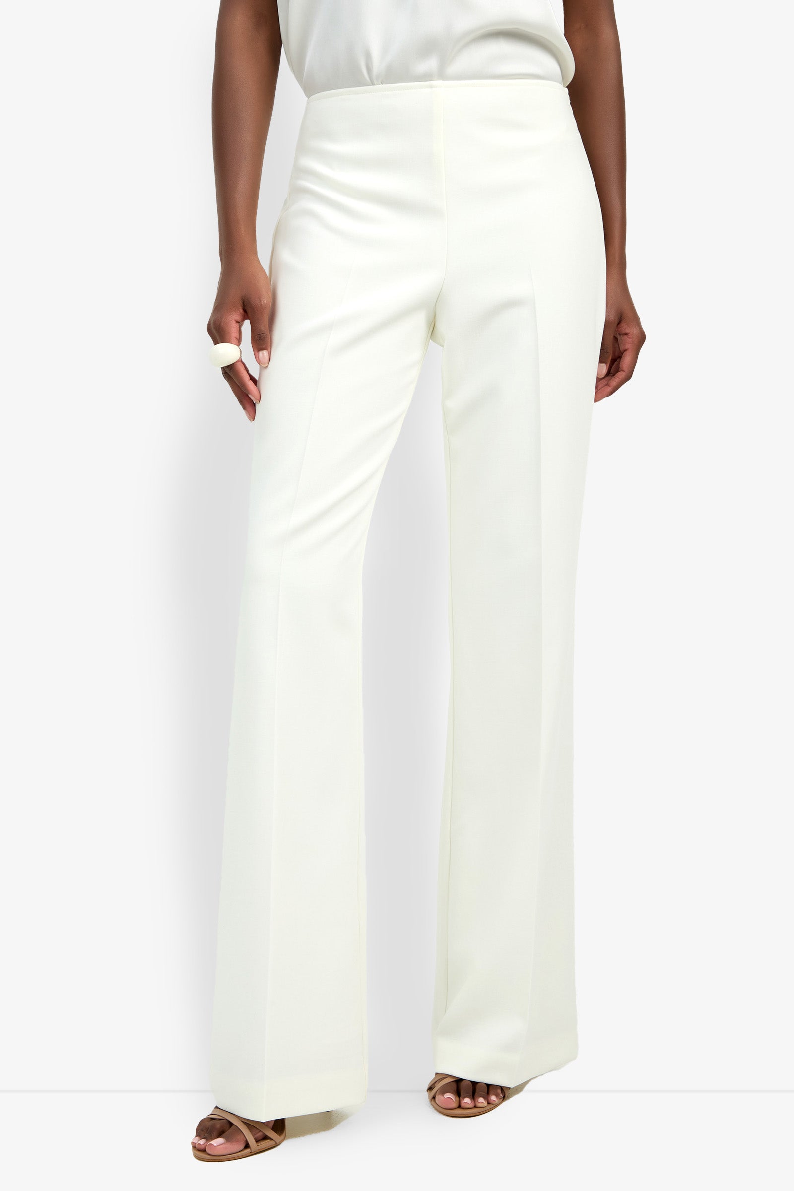 Someone models the CHIMAYO 2 PANT—high-waisted, white, wide-leg dress pants made from a soft polyester-viscose-elastane blend—styled with open-toe sandals against a plain white background.