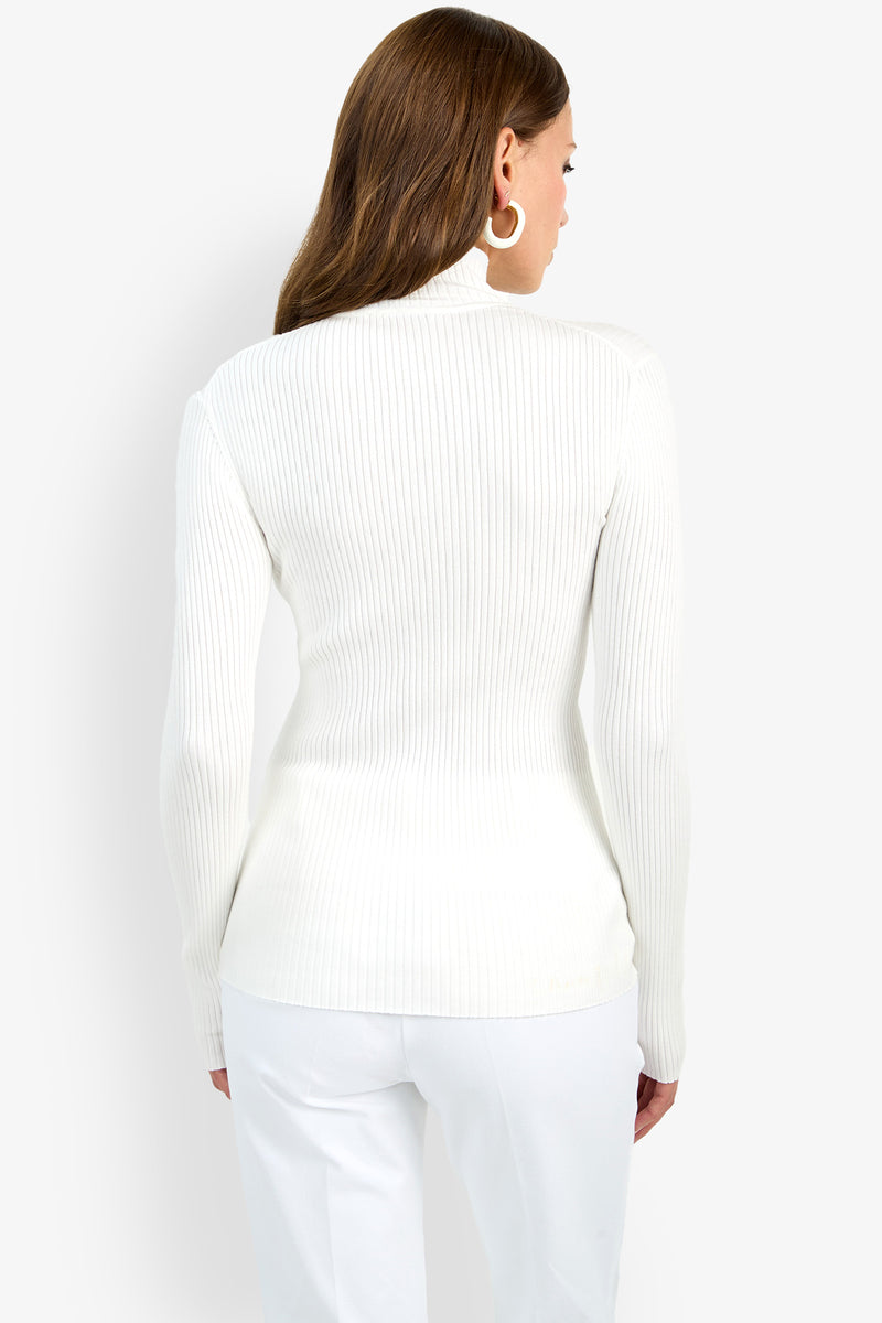 A woman with long brown hair models the Hempstead Mock Neck Top in white, paired with matching pants. She stands with her back to the camera against a plain light background.