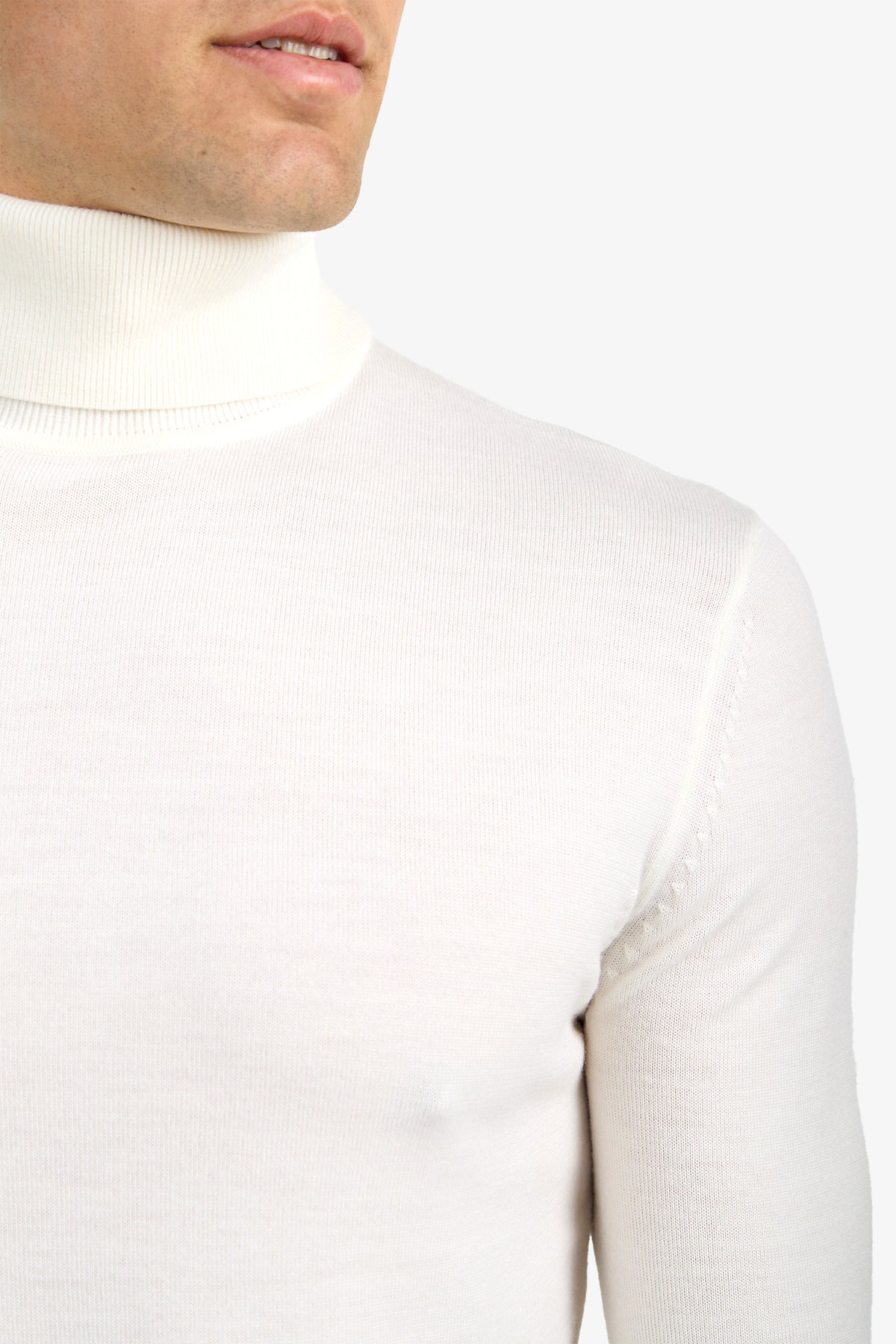 A close-up of a person wearing the Roy Long Sleeve Turtleneck in white, showing the lower half of their face and upper torso against a plain light background.