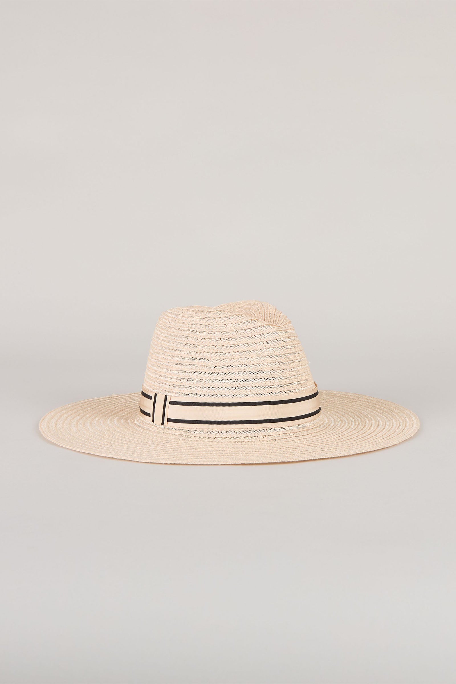 The Eugenia Kim Emmanuel Sun Hat, a wide-brimmed woven straw accessory with a black and white striped ribbon, is shown against a plain light background.