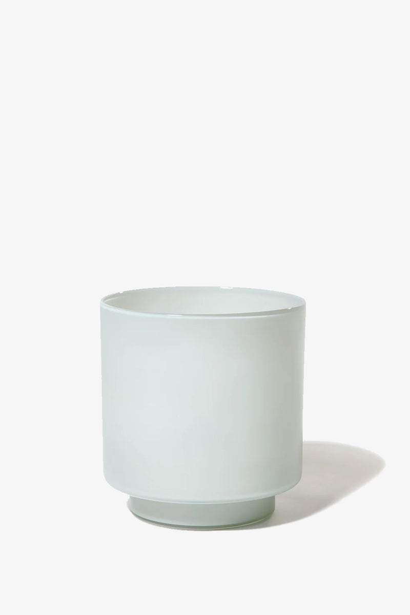The Fiorelli Low Container is a minimalist, light gray, cylindrical ceramic planter featuring a slightly raised base, shown against a plain white background.