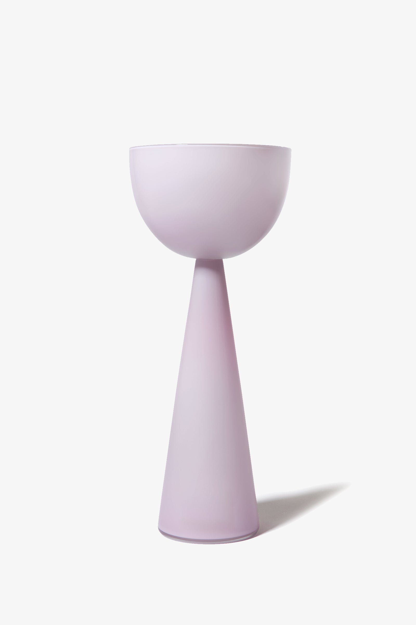 The Fiorelli Tall Bowl features a minimalist, modern pedestal design with a wide bowl-shaped top and a conical base, both finished in a soft pastel lavender color, set against a plain white background.