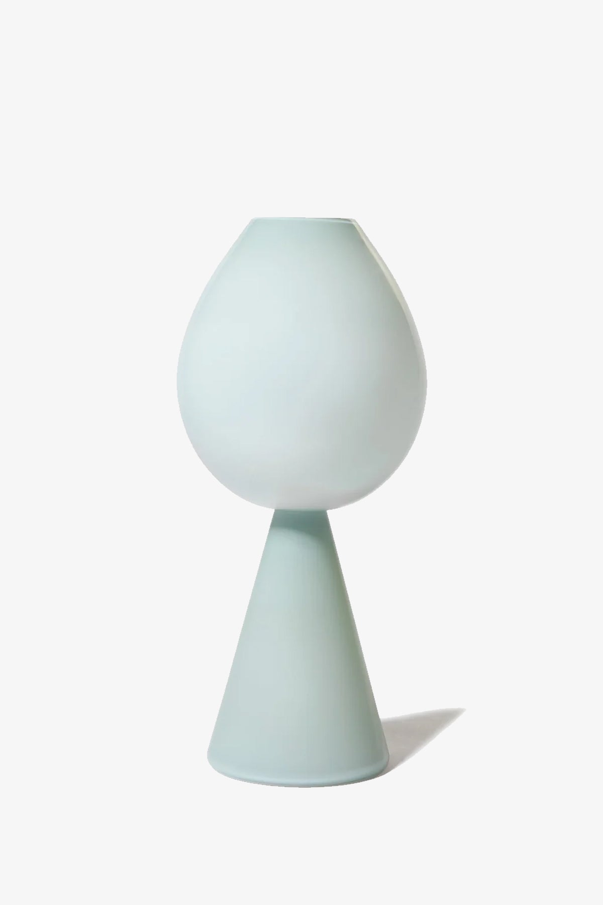 The Fiorelli Tulip is a modern, minimalist vase featuring a rounded top and a cone-shaped base in a smooth, light pastel blue finish, set against a plain white background.