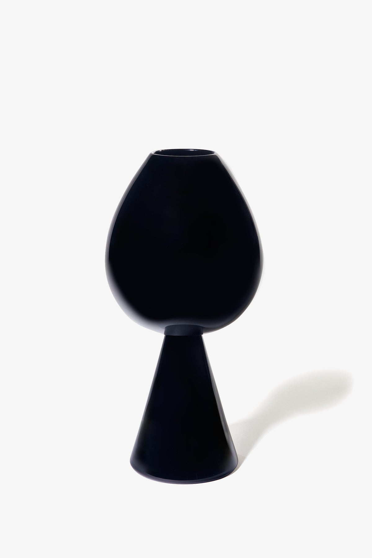The Fiorelli Tulip, a modern black vase featuring a rounded top and conical base, is showcased on a white background with its shadow cast to the right.