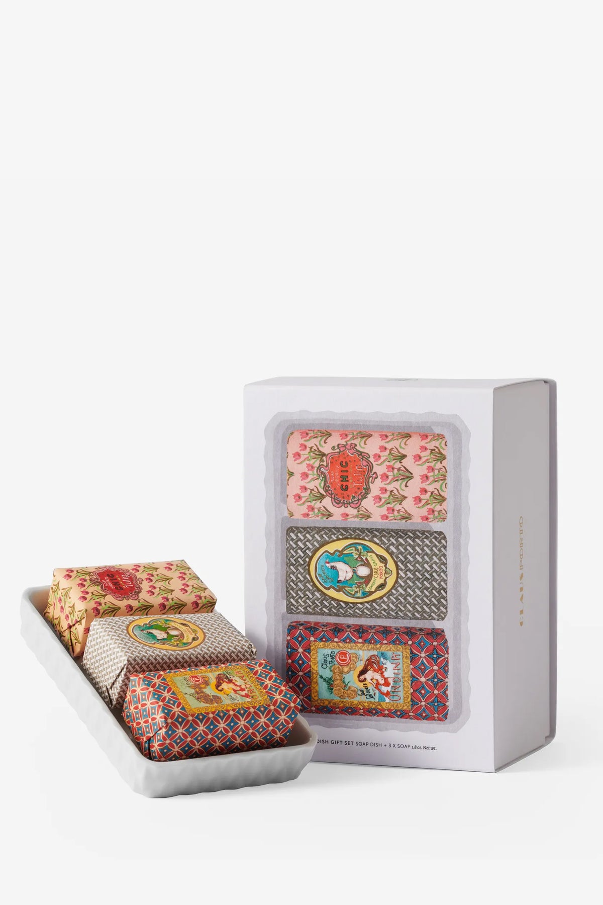 The Claus Porto Gift Set Soap Dish & Classico Mini Soaps features three patterned mini soaps, each wrapped in vibrant, decorative paper showcasing intricate floral and geometric designs. The set is elegantly displayed with an open tray holding the soaps.