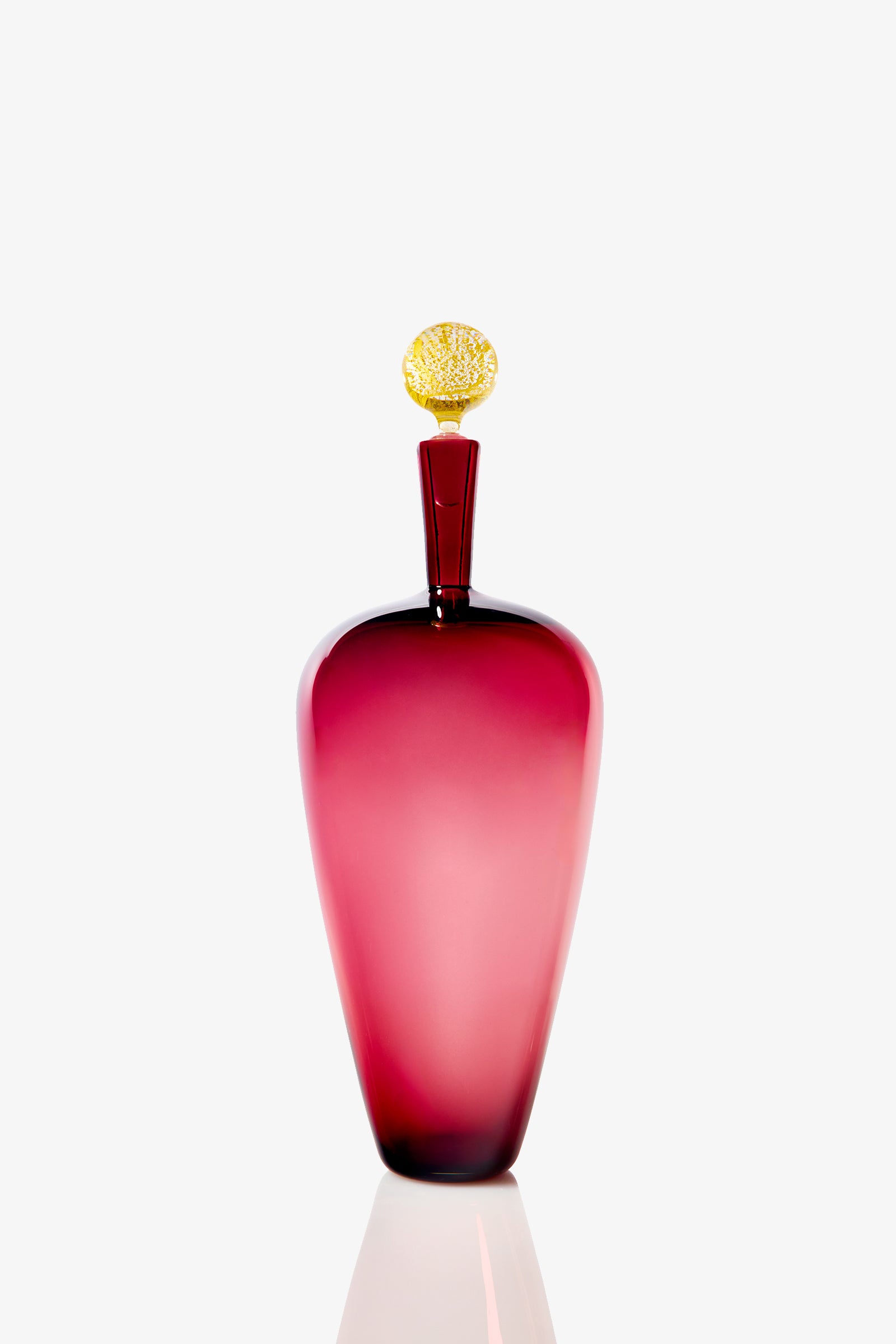 The High Shoulder Carmella Barware features a tall, elegant design with a gradient deep red color, rounded shape, and decorative gold cap, displayed on a reflective white surface against a plain background.