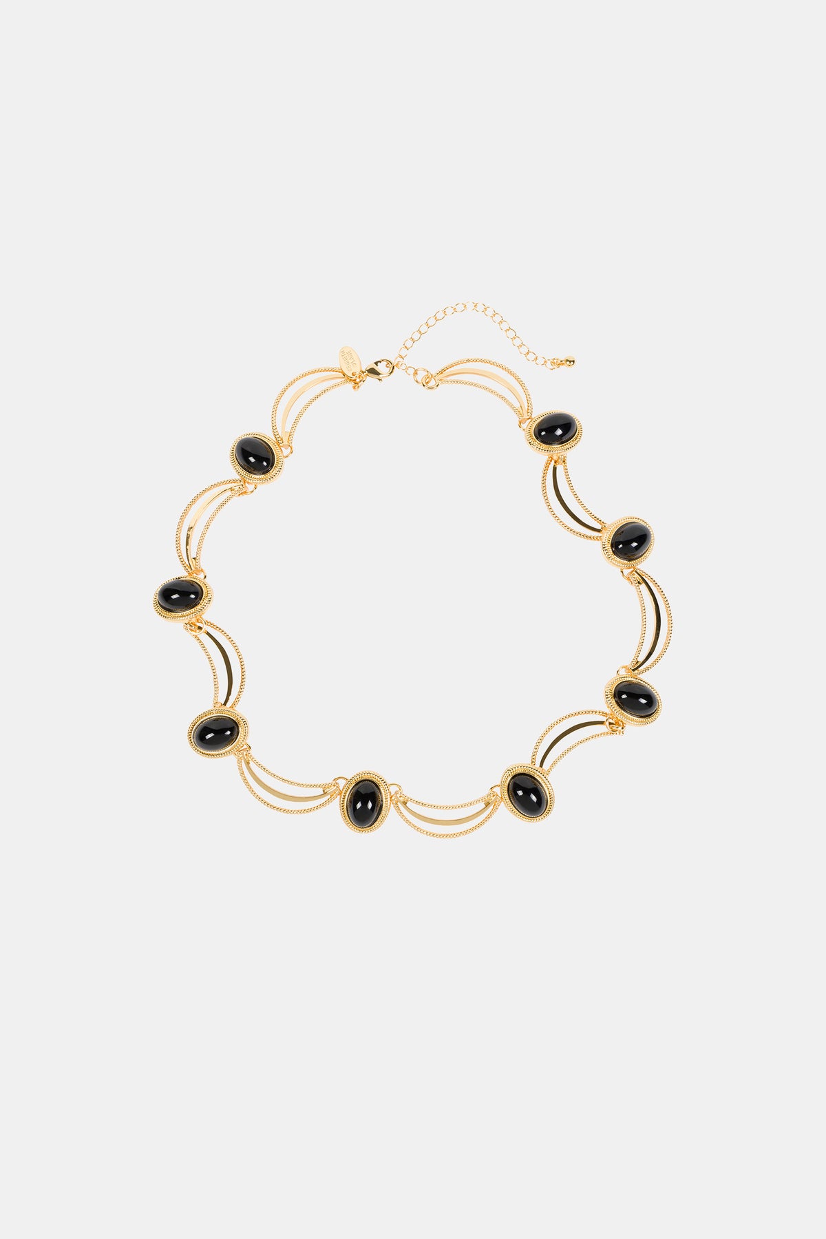 The Oval Jet Scallop Necklace features black oval stones in gold frames, joined by double gold chains and an adjustable clasp. Its elegant, symmetrical design makes it a standout accessory.