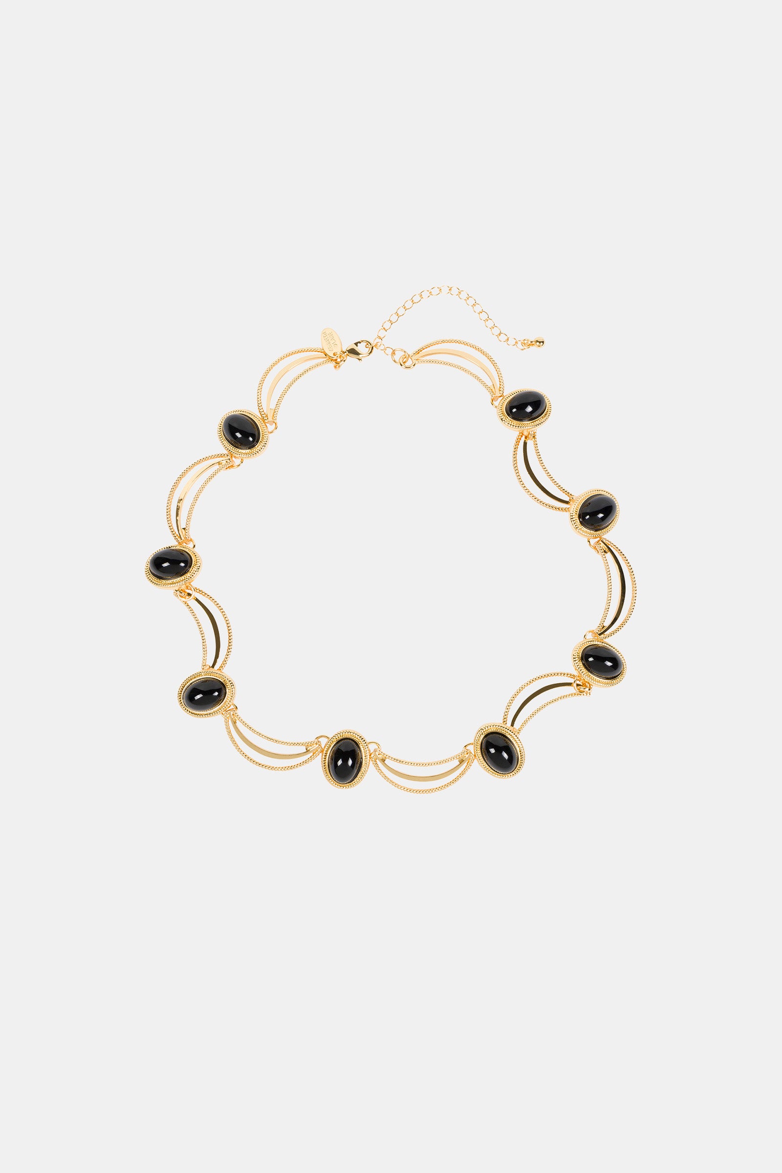 The Oval Jet Scallop Necklace features black oval stones in gold frames, joined by double gold chains and an adjustable clasp. Its elegant, symmetrical design makes it a standout accessory.