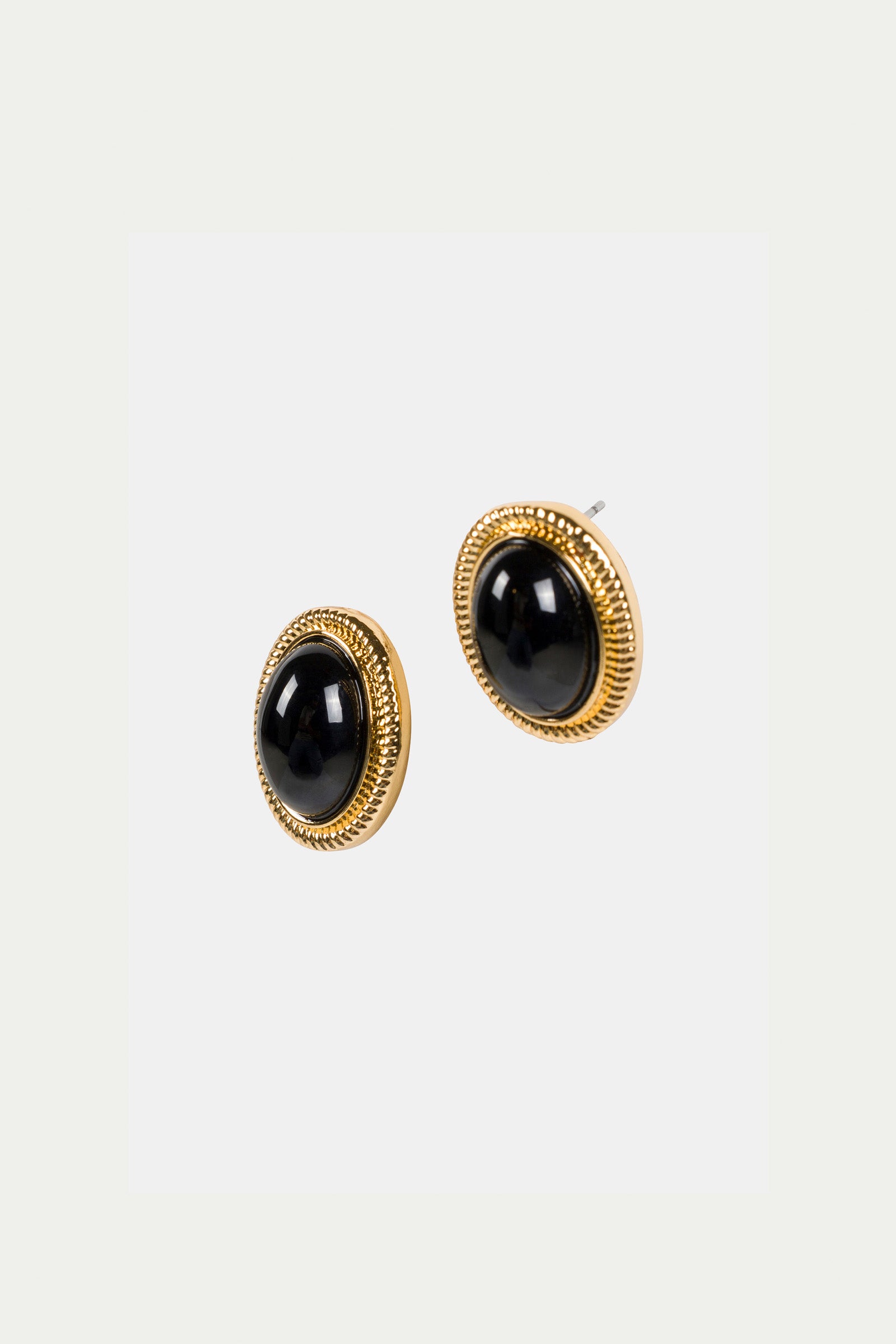 The Oval Jet Post Earrings feature gold-toned studs with black oval centers and a textured decorative border, shown against a plain white background.