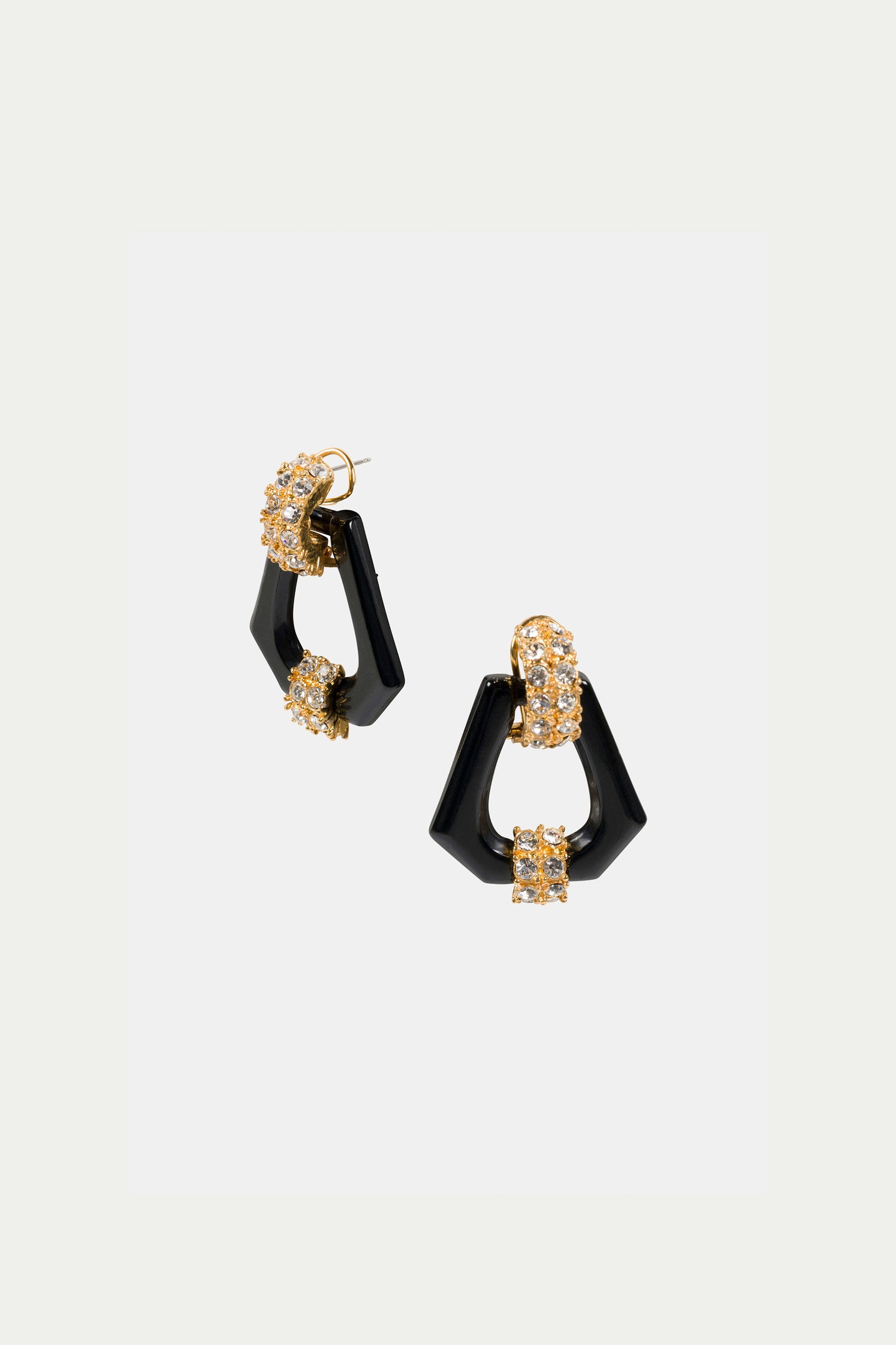 The Hexagon Doorknocker Earrings are geometric black earrings with gold and crystal accents, featuring angular shapes and a modern, elegant design, shown against a plain white background.