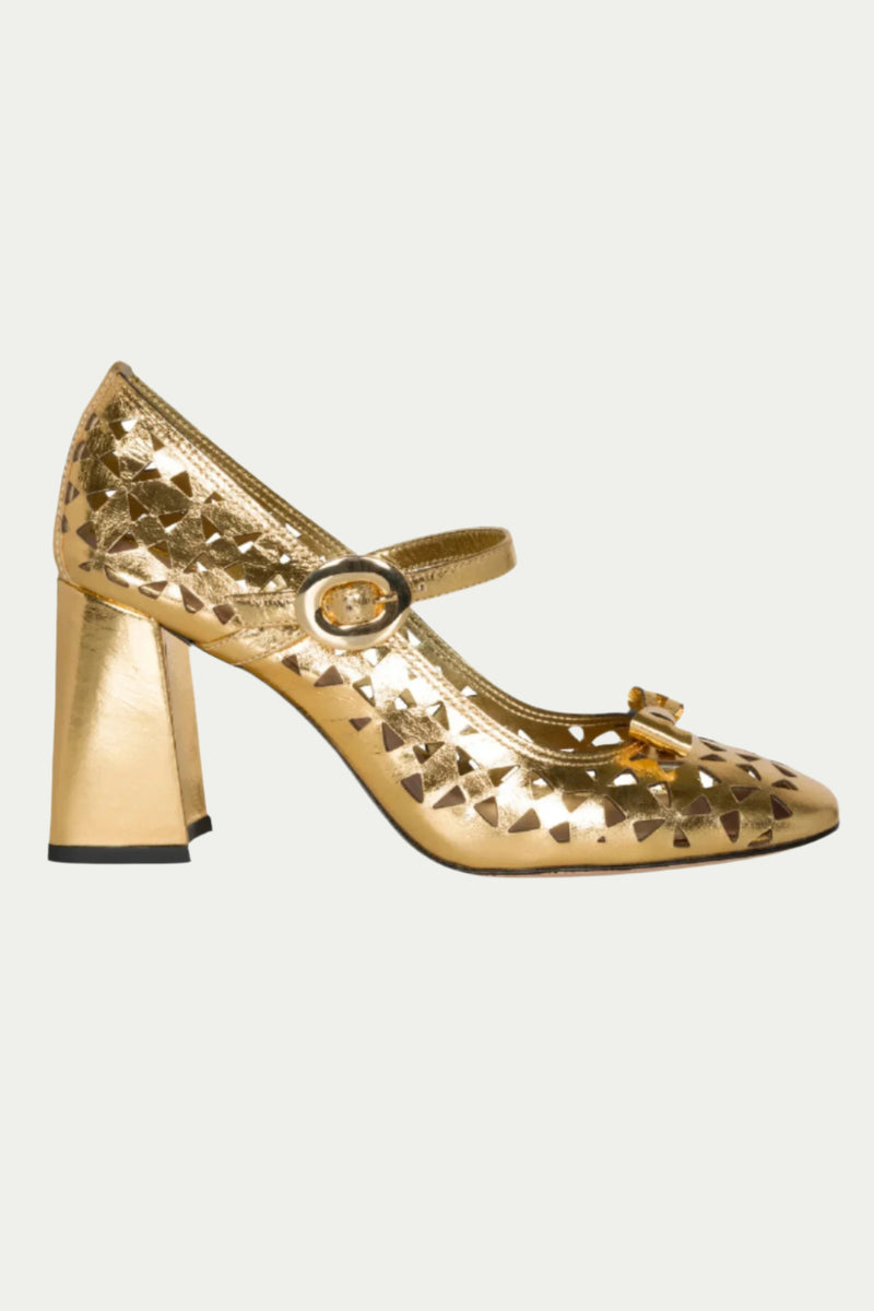 The Georgina Mary Jane Cutout Leather Heel in gold features a chunky high heel, geometric cut-outs, round buckle strap, and a small toe bow, shown in side profile against a light background.