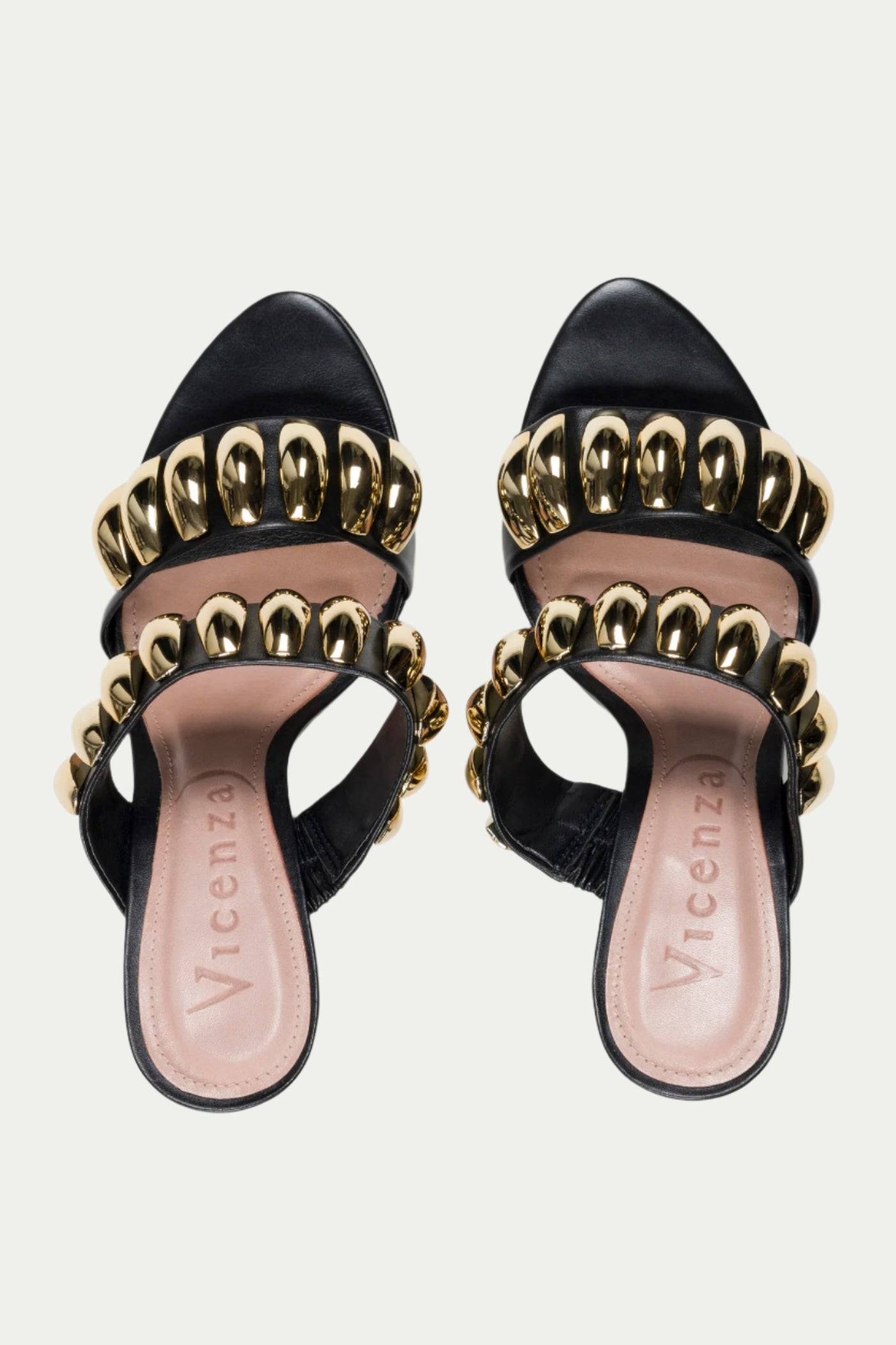 The GOLDEN VOLUME HEEL SANDAL features black and gold heeled sandals with stiletto heels, gold chain accents on the straps, and â€œVicenzoâ€ branding printed on beige insoles.