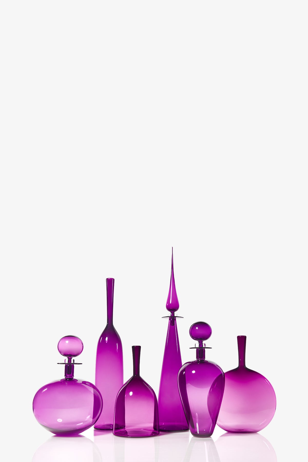 A Large Angelic Bottle with an elegant purple glass design and a unique stopper stands on a reflective surface against a plain white background.