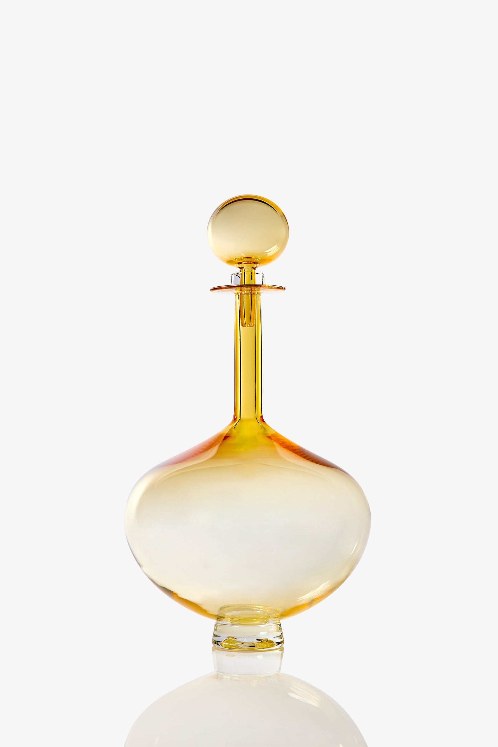 A Large Genie Bottle Decanter, crafted from clear glass with a round stopper and tinted in shades of yellow and orange, is displayed against a white background.