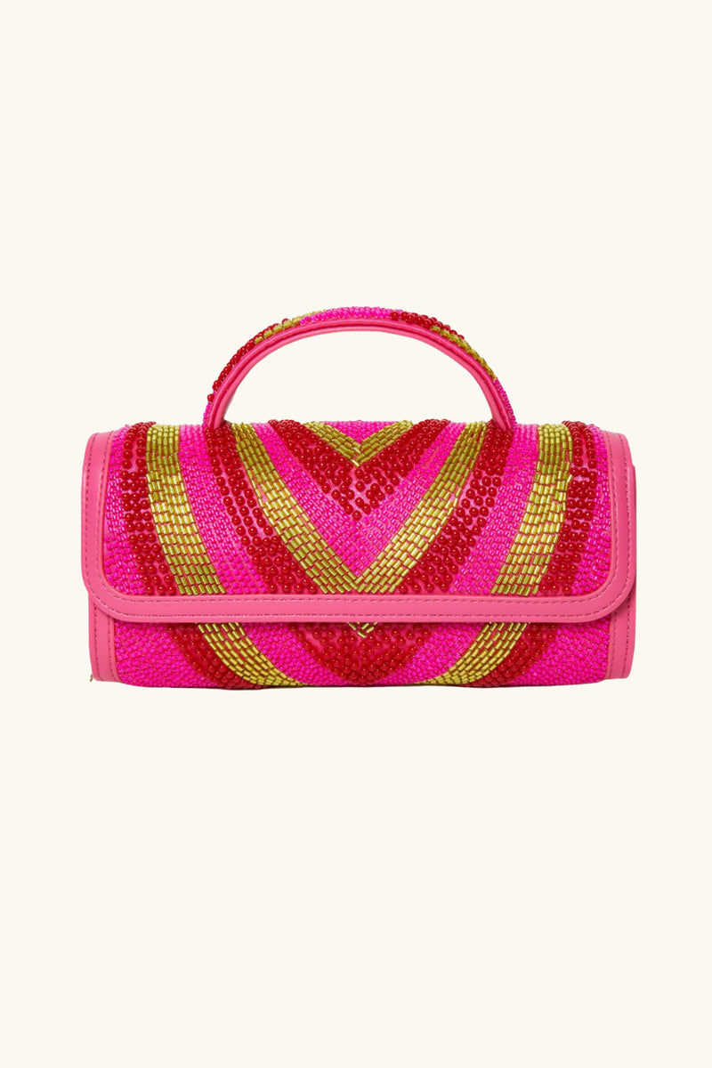 The Lele Sadoughi x Trina Turk Mini Tabitha Bead Bag is a small cylindrical handbag with a top handle, featuring bright pink, red, and gold sequin chevron patterns and pink trim on the edges and handle.