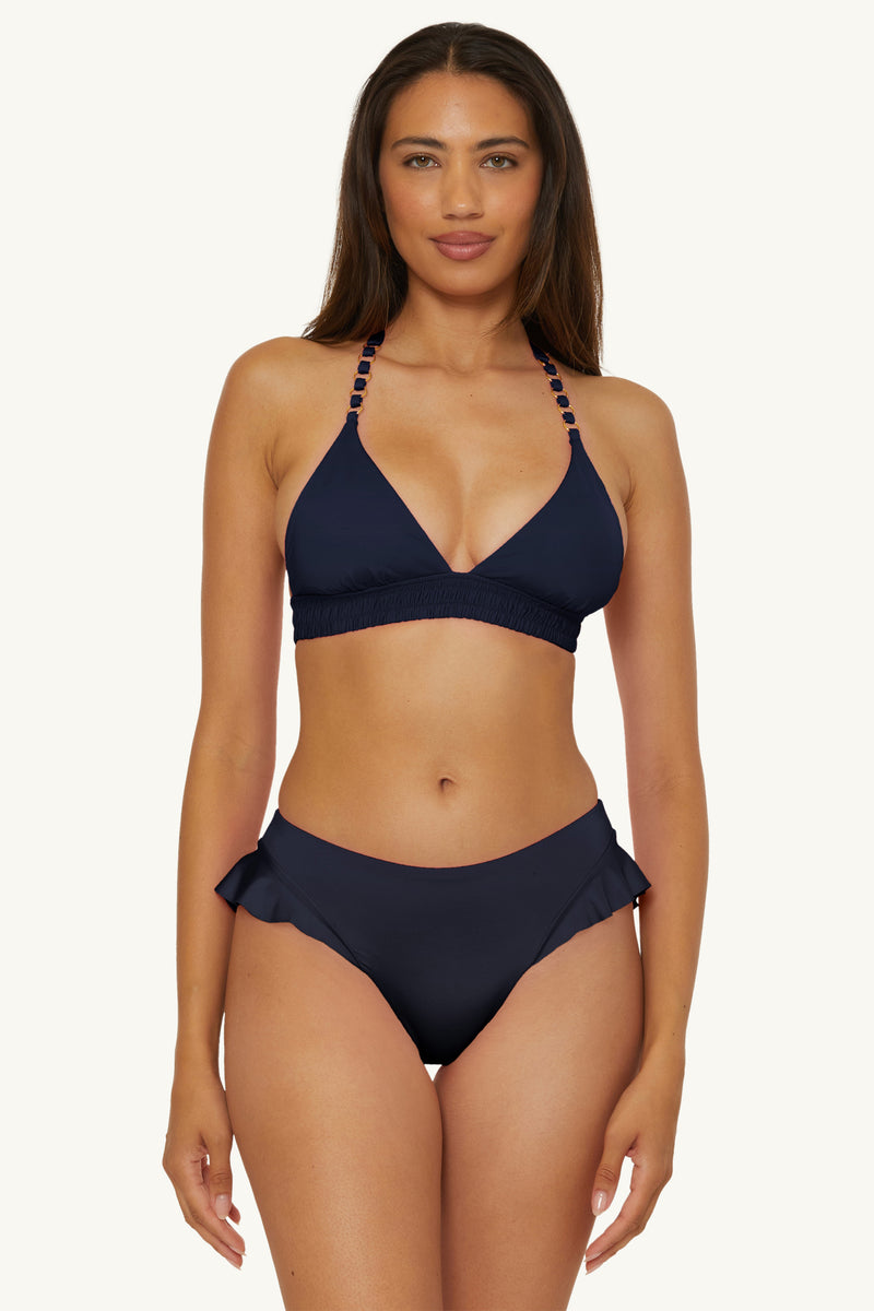 A woman faces forward against a plain light background, wearing the Ring Halter Swim Top in Monaco, paired with matching bikini bottoms.