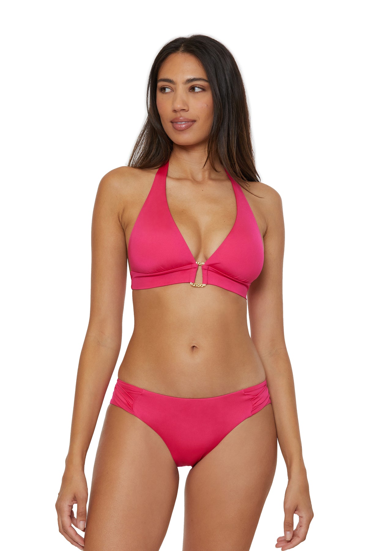 A woman wearing the Monaco Banded Halter Swim Top in Cannes Coral, featuring a gold center accent, stands and looks slightly to her left against a plain white background.