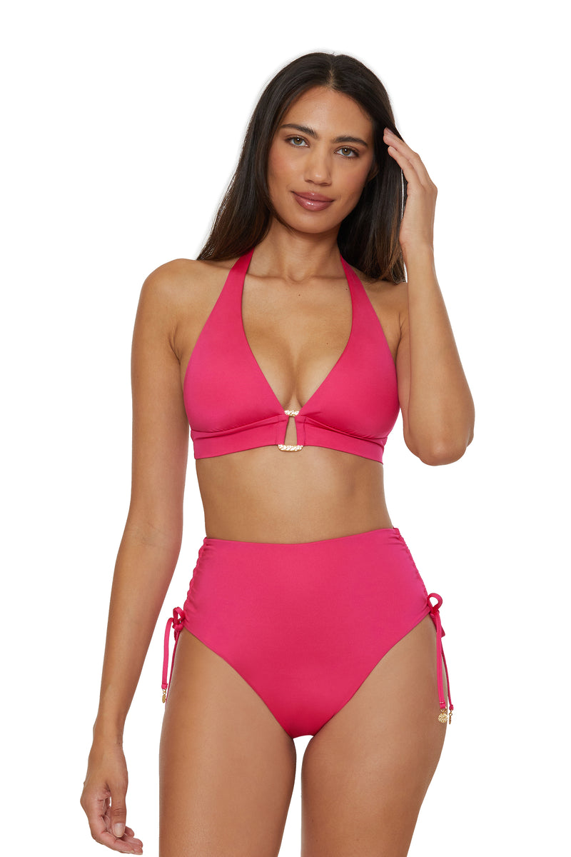 A woman wears the Monaco Shirred Tie High-Waist Swim Bottom and a bright pink halter bikini top, standing against a plain white background.