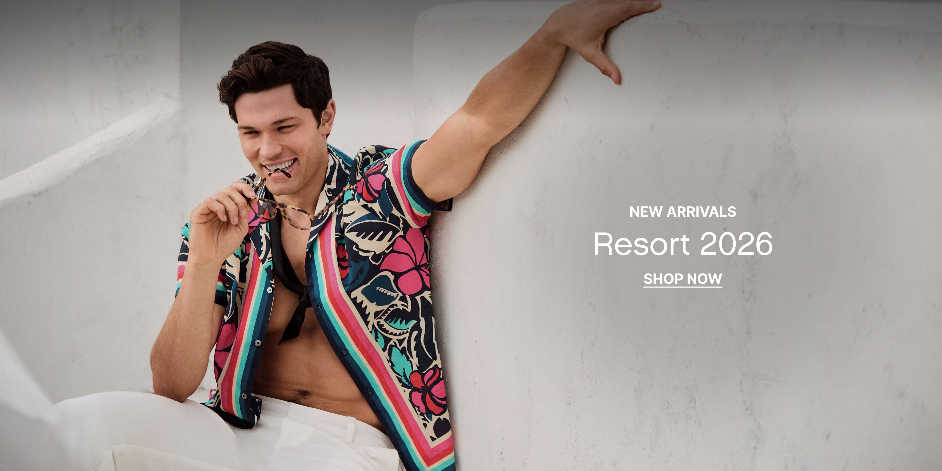 Man wearing a colorful shirt with text 'New Arrivals Resort 2026 Shop Now' on a white background