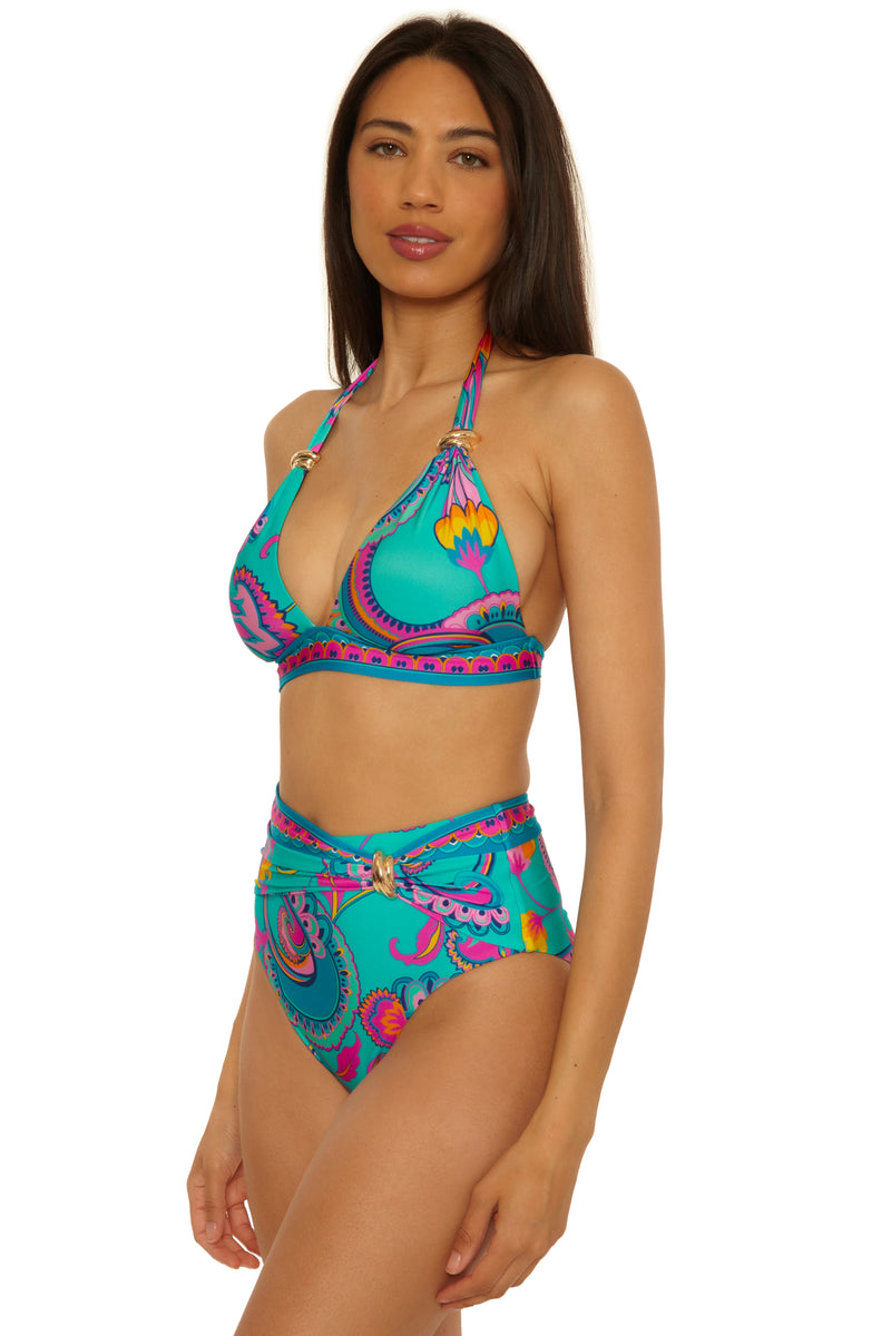 A woman models the Mykonos Belted Hi Waist Bottom in a turquoise paisley print bikini, standing at an angle with long dark hair and a neutral expression.