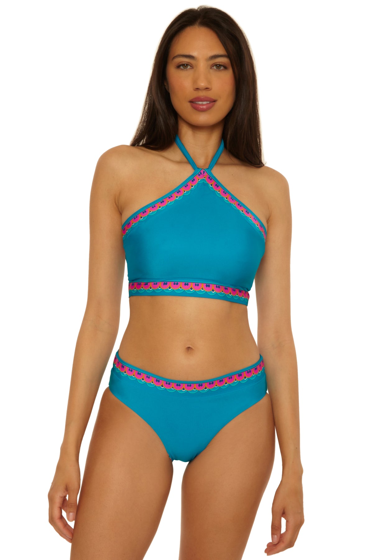 Woman wearing the Mykonos Reversible Hi Neck Top in turquoise with pink and blue trim, standing against a plain white background.