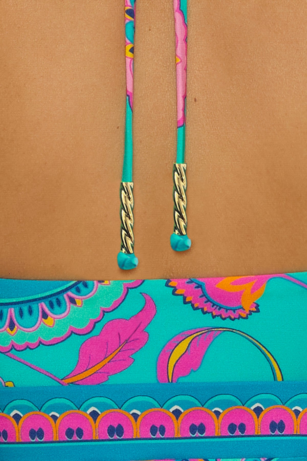 Close-up of the back of a person wearing the Mykonos Bandeau Tankini, featuring brightly colored pink, yellow, and purple patterns with teal neck ties finished with gold tips.