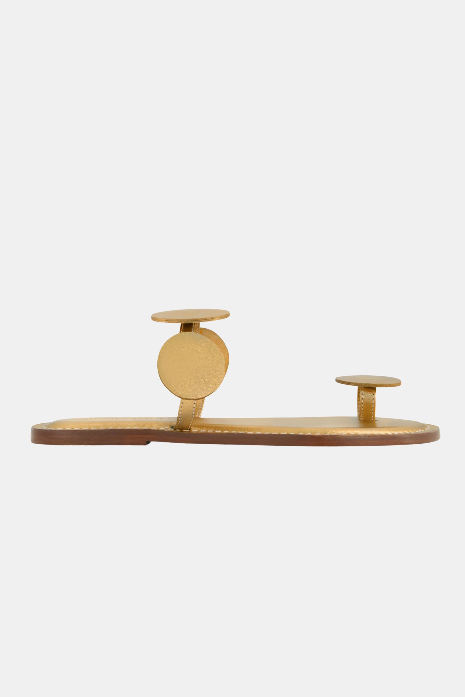 The Bernardo New Moon Sandal features a minimalist design with a tan sole and two circular tan leather straps, one at the toes and one at the instep, displayed against a plain white background.