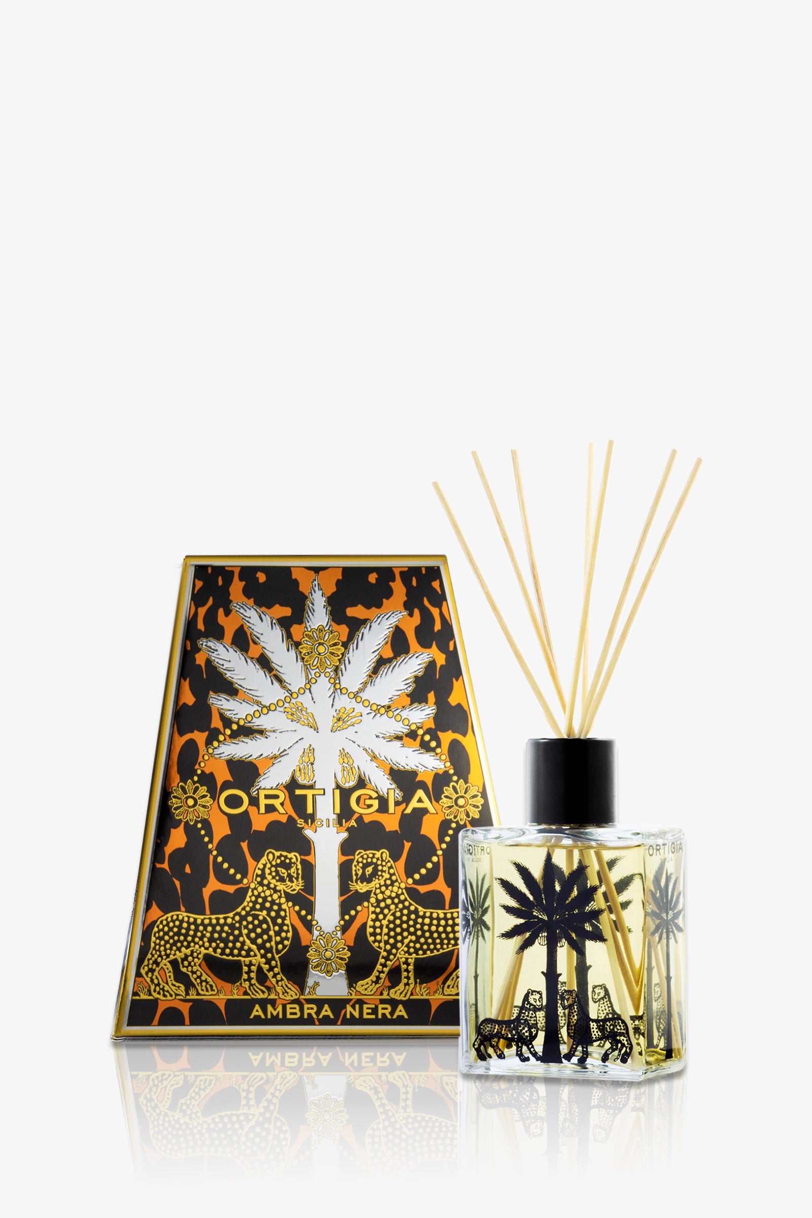The Ortigia Ambra Nera Diffuser includes a decorative clear glass bottle featuring black palm and leopard designs, packaged in a black and orange box adorned with two gold leopards and palm trees.