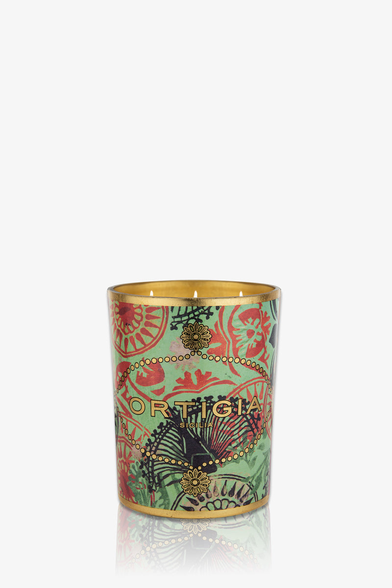 The Ortigia Fico D'India Large Candle features a decorative green glass holder with gold and red floral patterns, the ORTIGIA logo on the front, and a gold interior.