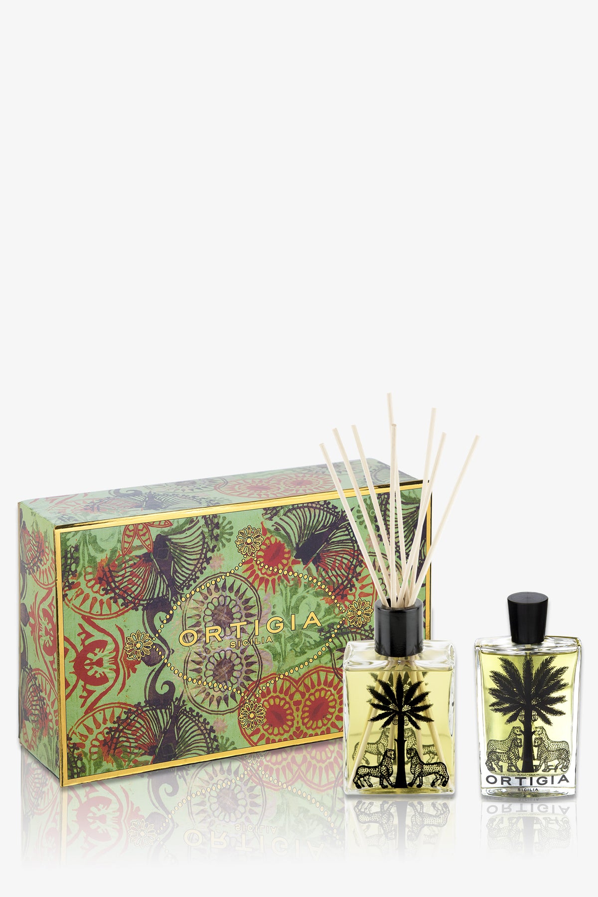 The Ortigia Fico D'India Casa Set in green includes a decorative box, a square glass reed diffuser with a black palm tree design, and a matching bottle of liquid perfume.