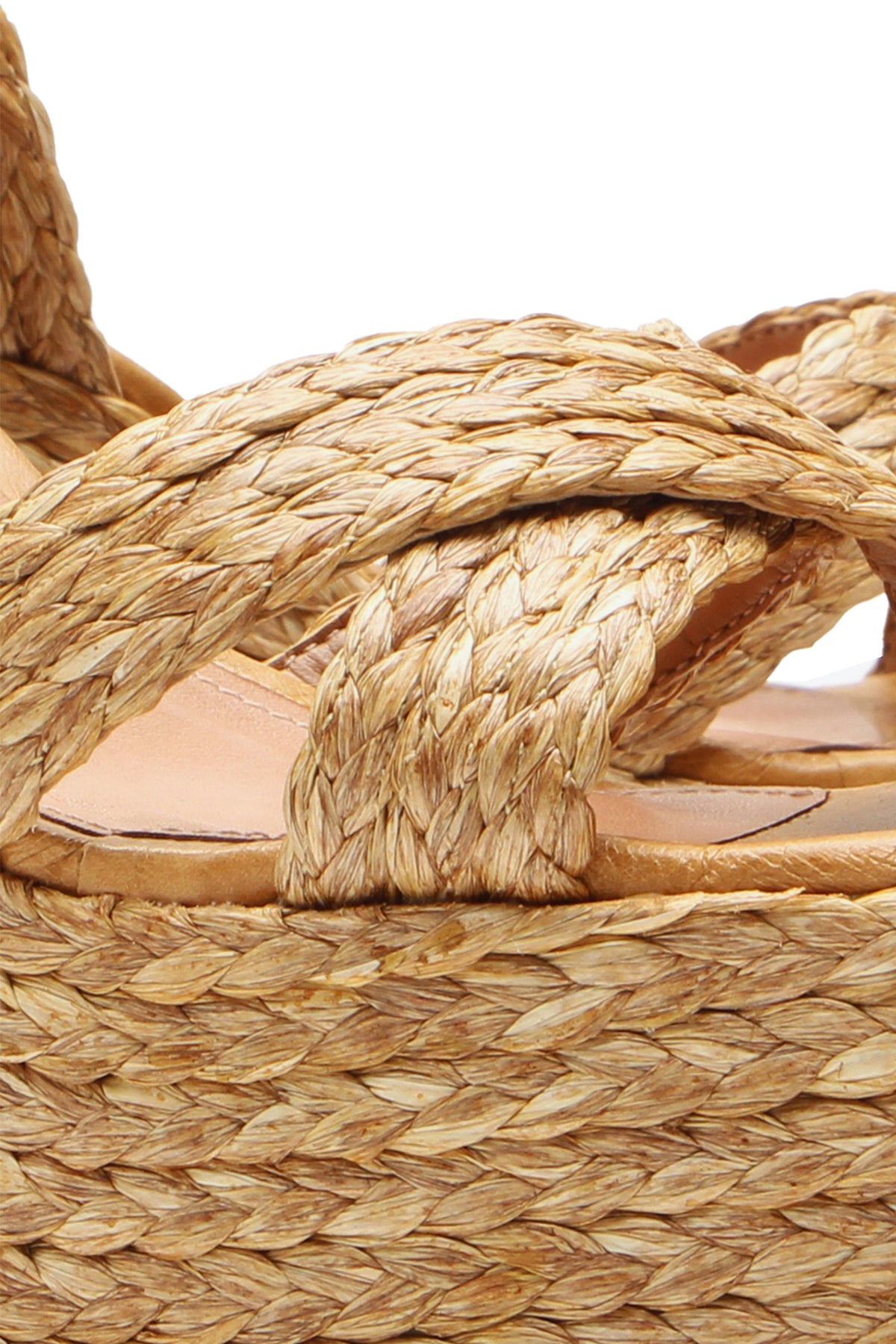 Close-up of the Garda Platform, a sandal featuring thick braided straps and a woven straw platform sole, highlighting its detailed texture and natural color.