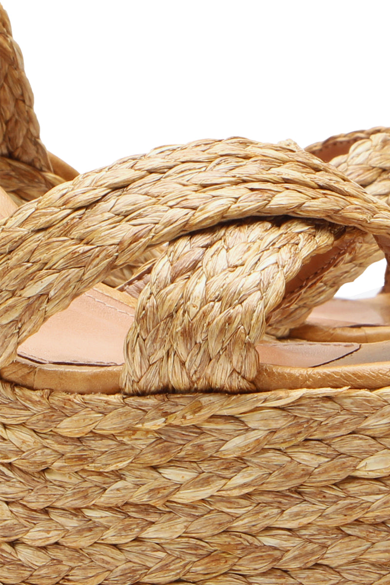 Close-up of the Garda Platform, a sandal featuring thick braided straps and a woven straw platform sole, highlighting its detailed texture and natural color.
