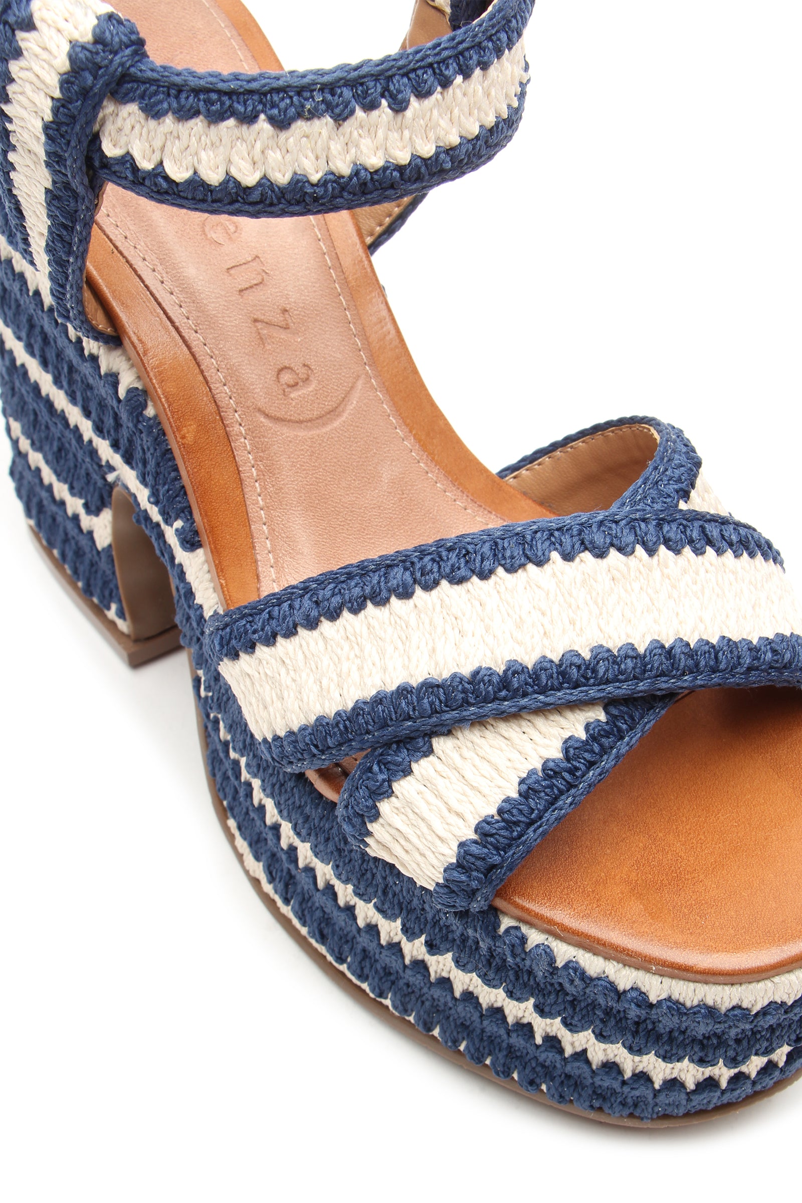 A close-up of the Zamzibar Platform sandal, featuring blue and white braided straps and trim, a chunky high heel, a tan insole, and visibly textured woven material.