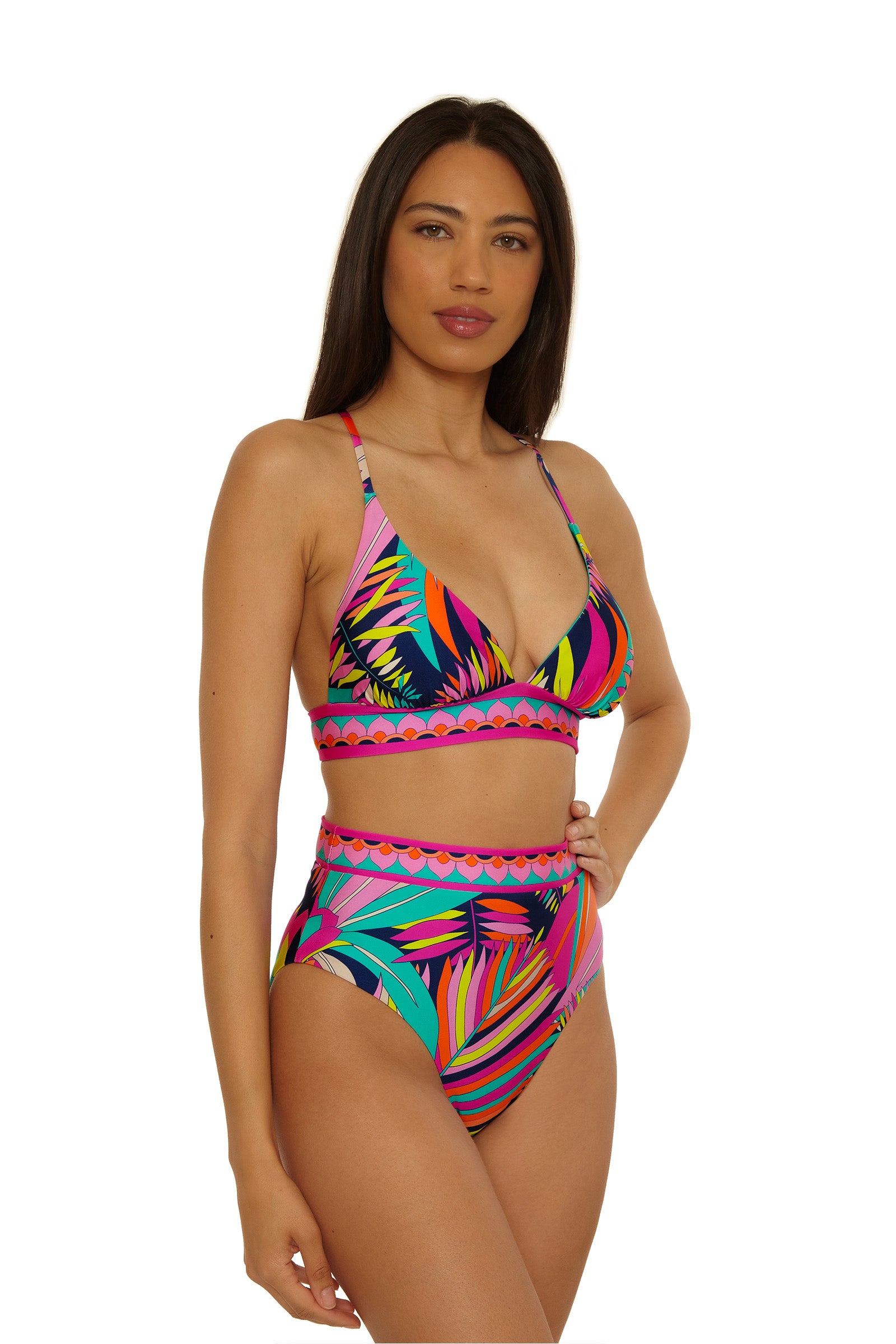Woman wearing the Paralia Rev Hi Waist Bottom bikini in a colorful tropical print with a bralette top, standing against a plain white background.