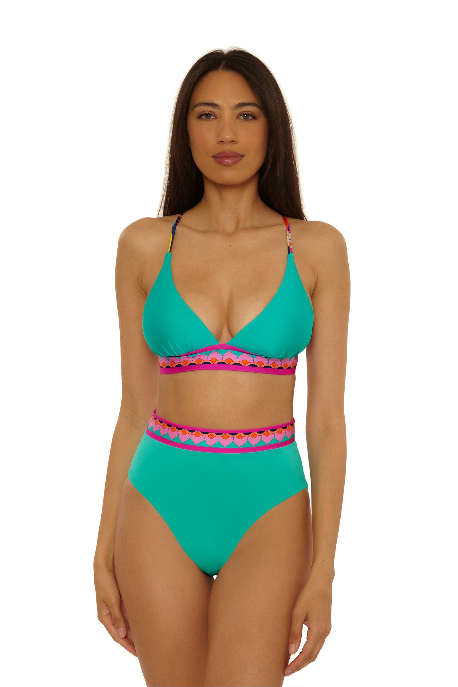 A woman with long brown hair wears the Paralia Rev Hi Waist Bottom bikini in turquoise, featuring pink and orange geometric trim at the waistband and straps. She stands facing forward against a plain white background.