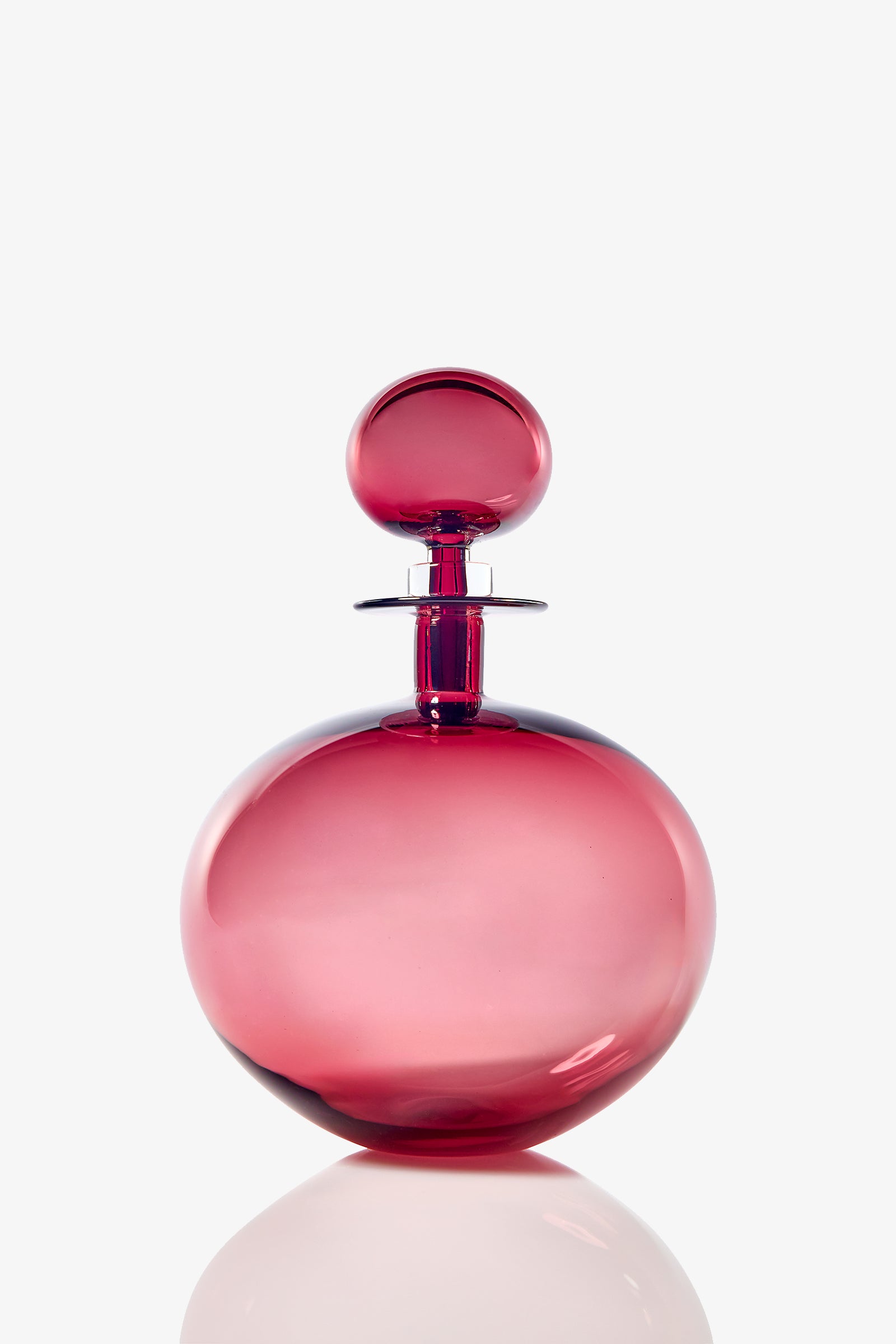 The Small Angelic Bottle is a round, elegant perfume bottle made of translucent pink glass with a matching spherical stopper, displayed against a plain white background.