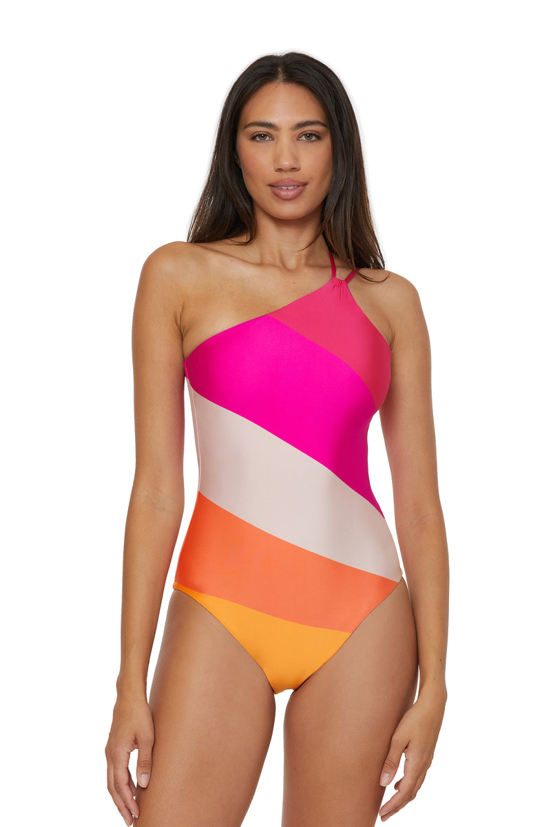 A woman wearing the Sunburst One-Shoulder One-Piece Swimsuit, featuring vibrant color blocks, stands against a white background and looks at the camera with a neutral expression.