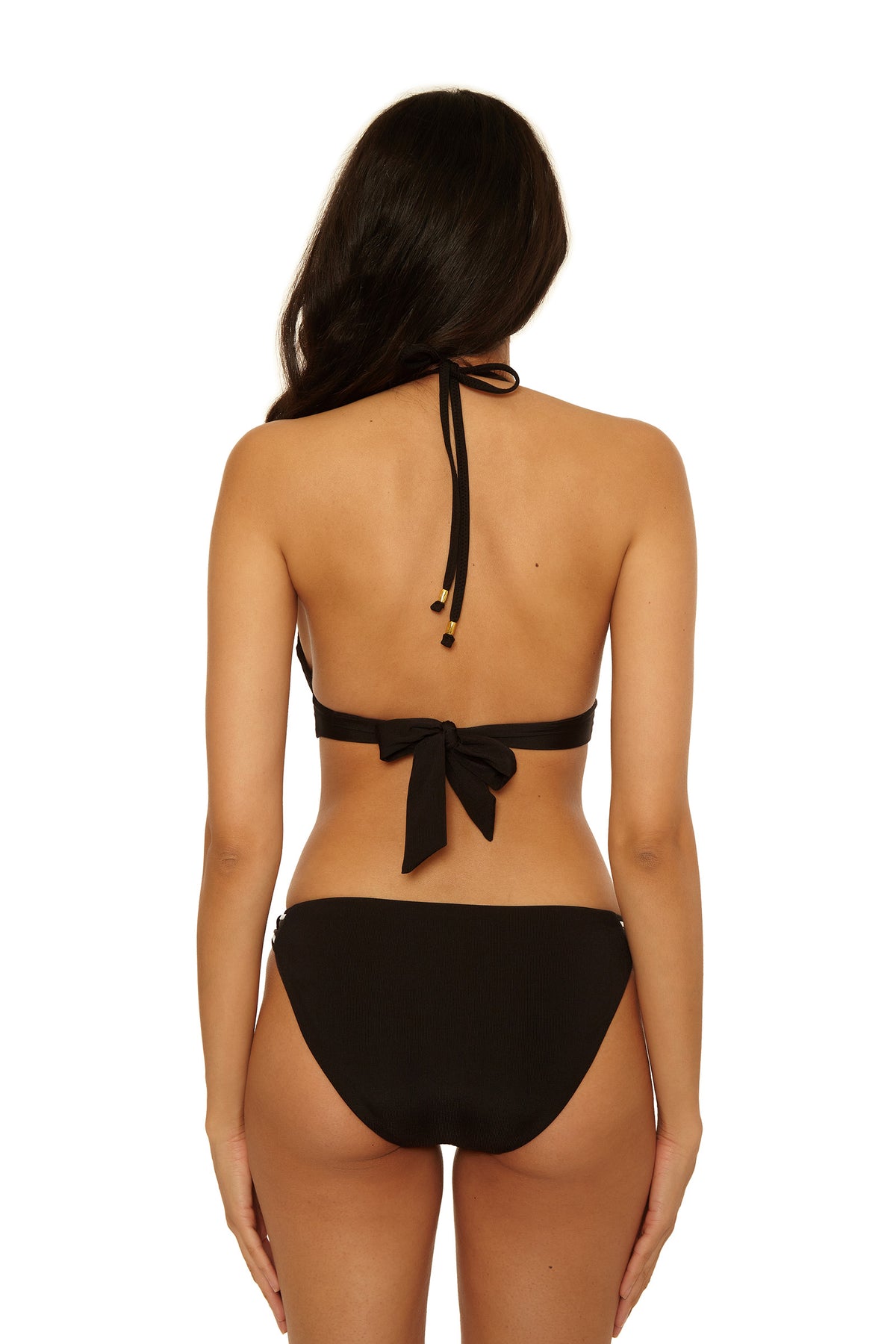 A woman with long dark hair is seen from the back, wearing a black Triumph Braided Hipster Swim Bottom and a matching halter bikini top. The background is plain white.