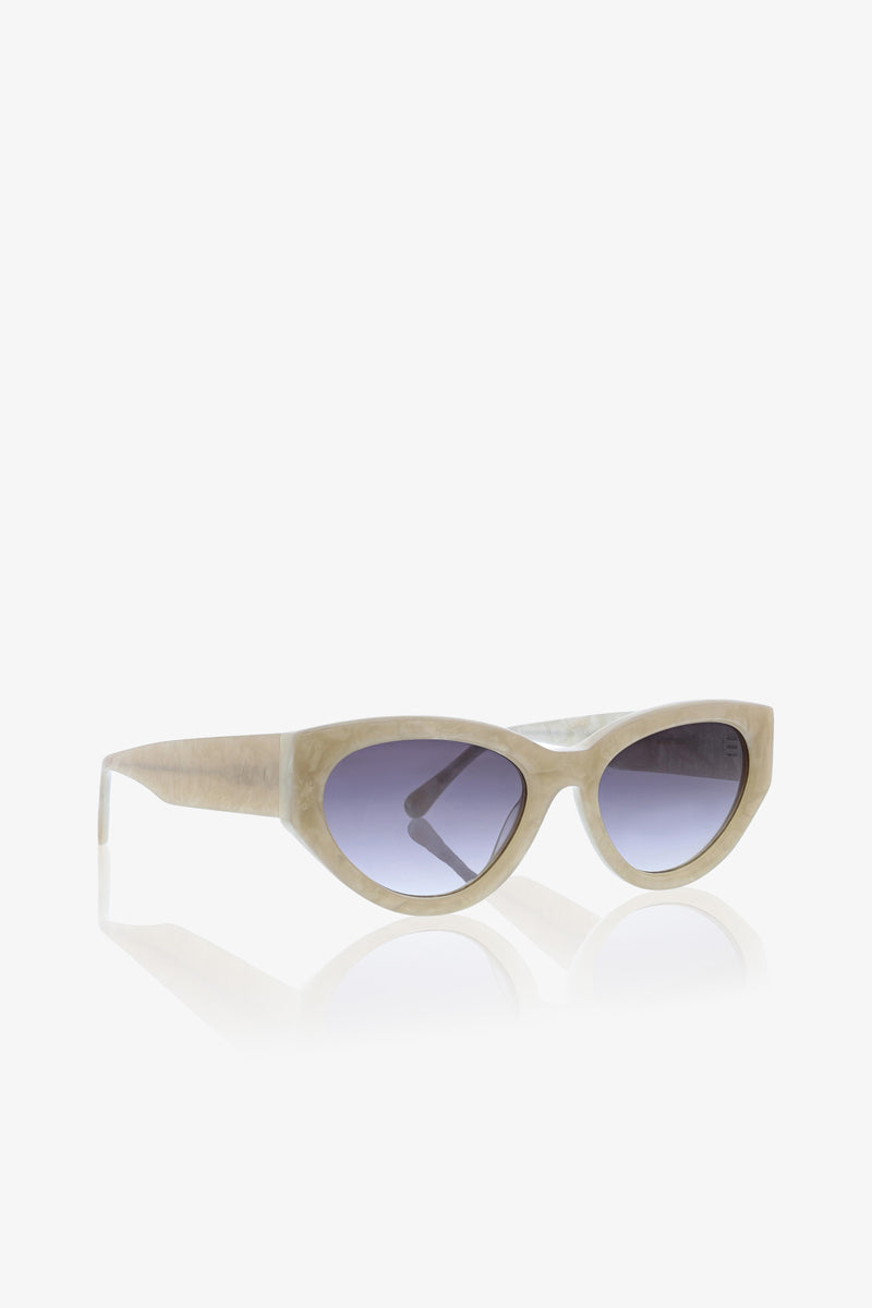 Boulders Sunglass in beige showcases bold cat-eye frames with dark gradient lenses, presented on a white background with a soft reflection beneath.