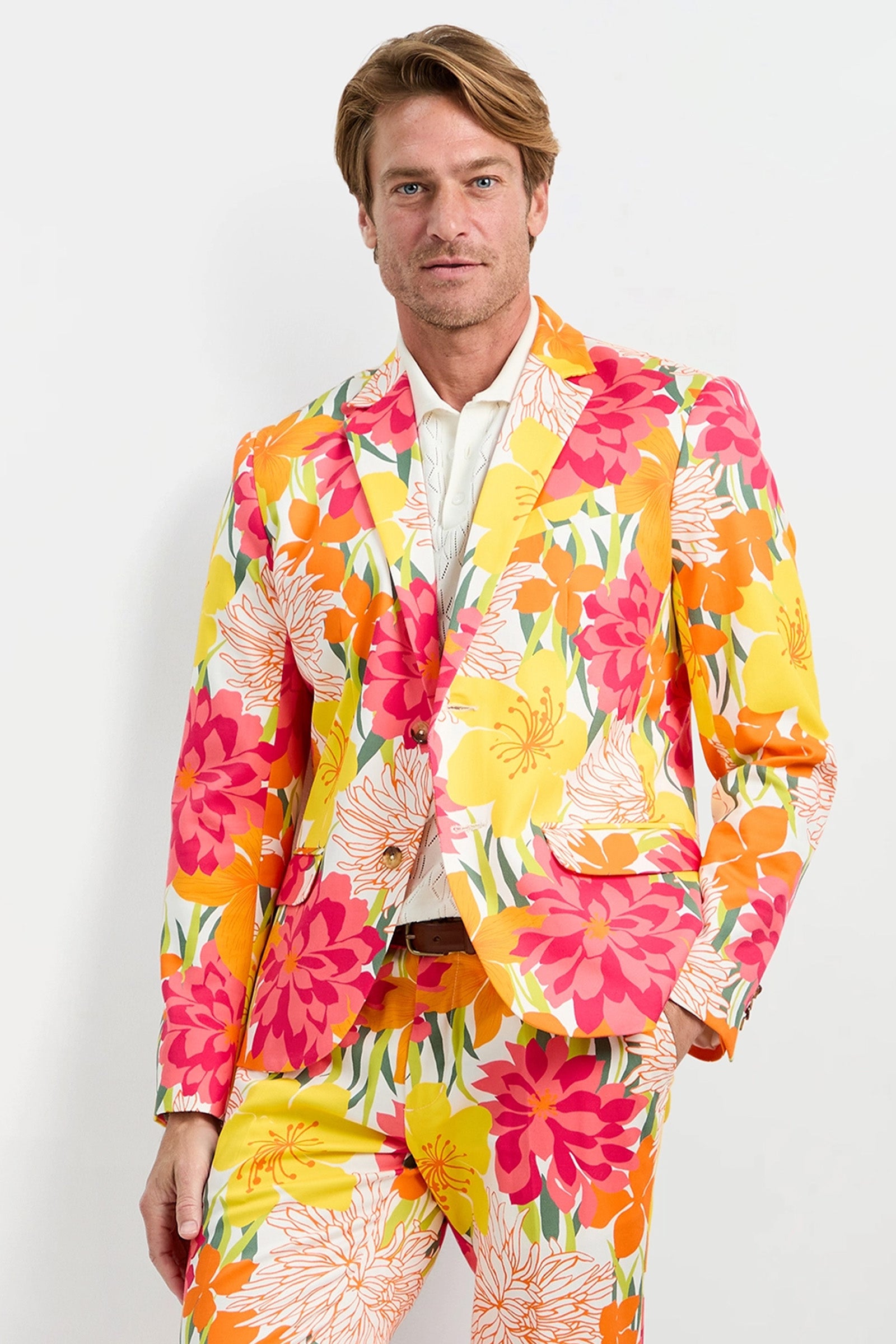 A man wears the Thurston Blazer - Como Herringbone over a white shirt, standing against a plain white background.