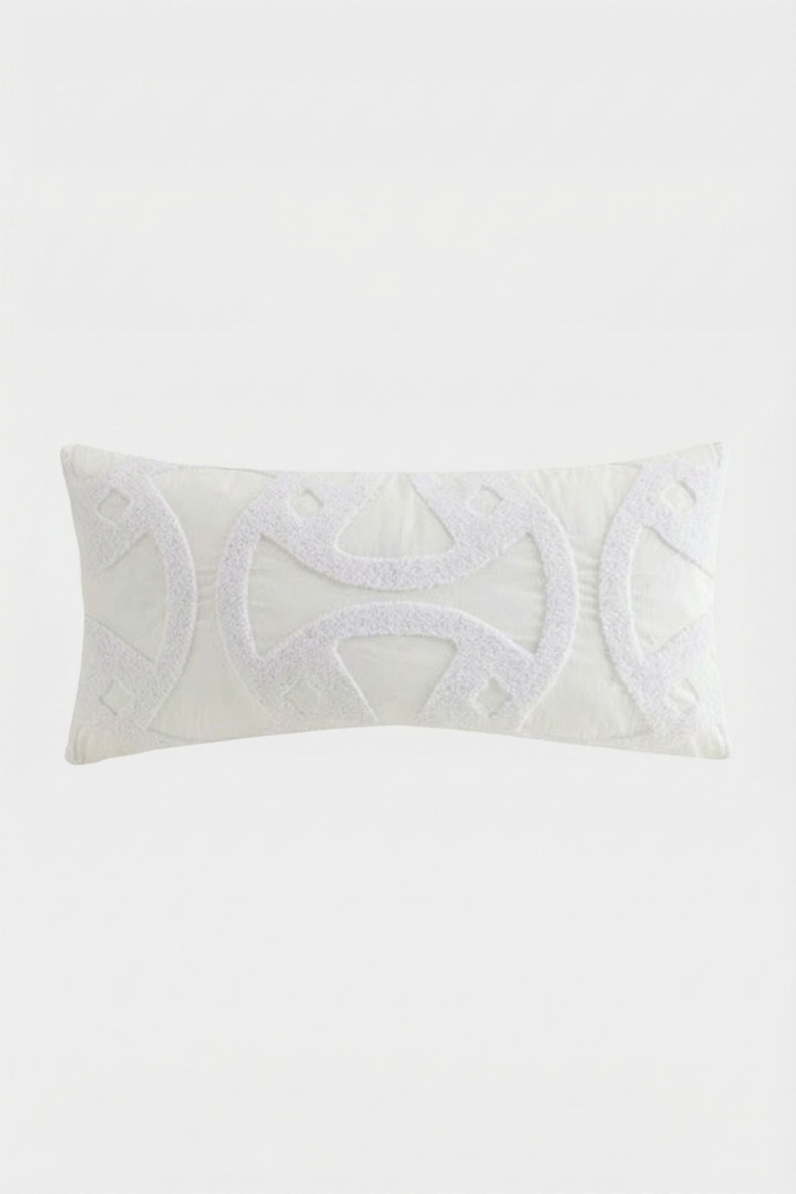 The Santorini White Tufted Throw Pillow 12"X24" features textured geometric patterns and symmetrical curved designs on a plain white background.