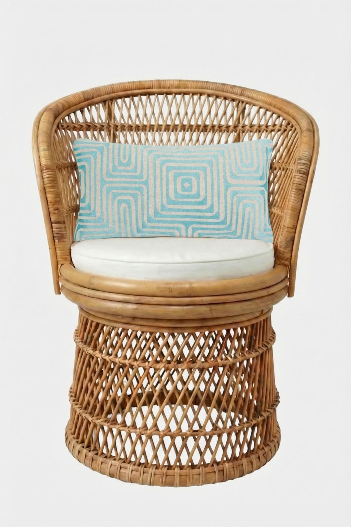 A round wicker chair with a cream cushion and the Amazing Maze Embroidered Lumbar Pillow, which is rectangular, light blue, and features a geometric pattern, set against a plain white background.