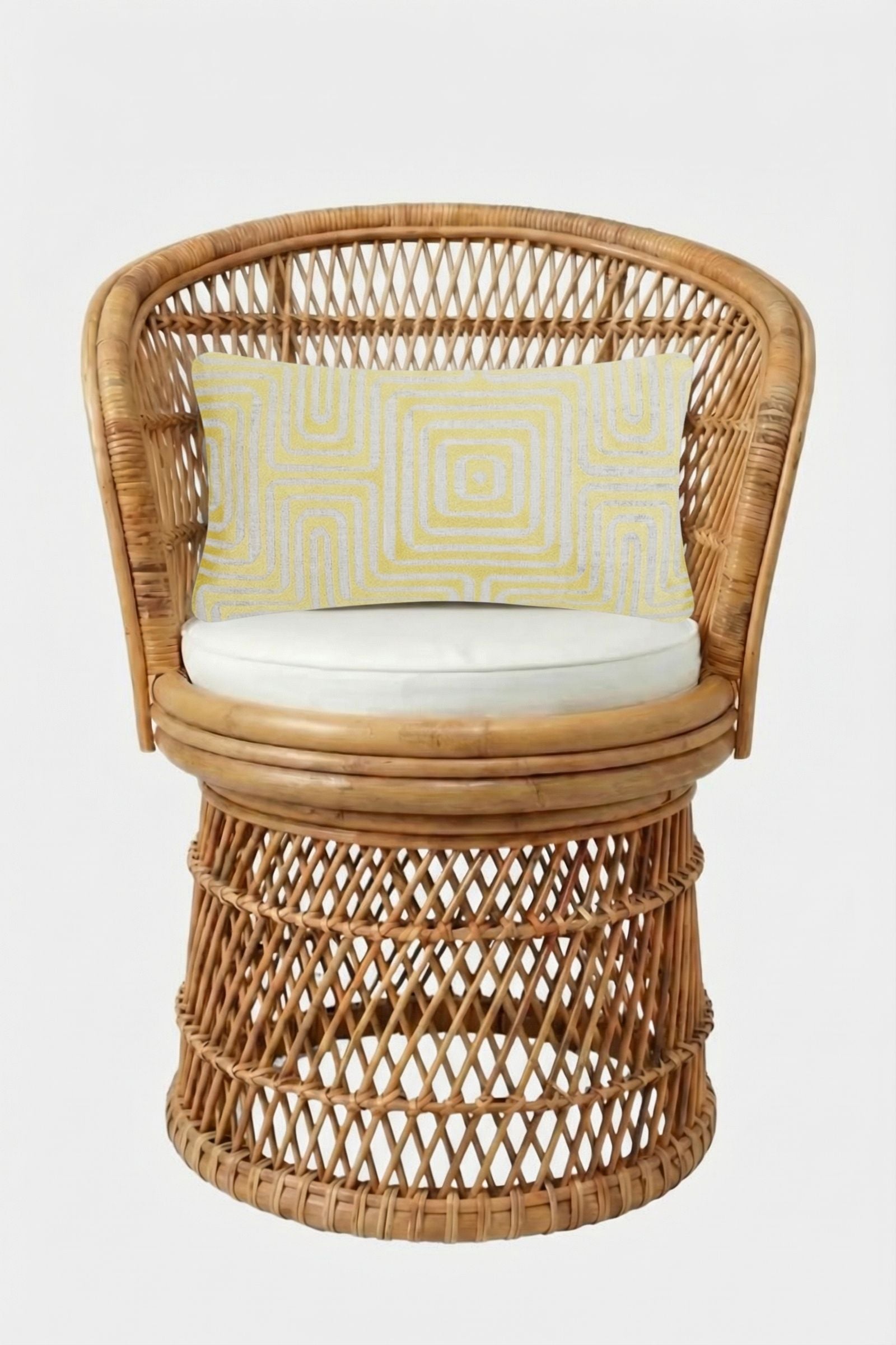 A round woven rattan chair with a curved back, white seat cushion, and the Amazing Maze Embroidered Pillow featuring a yellow and white geometric pattern, set against a plain white background.