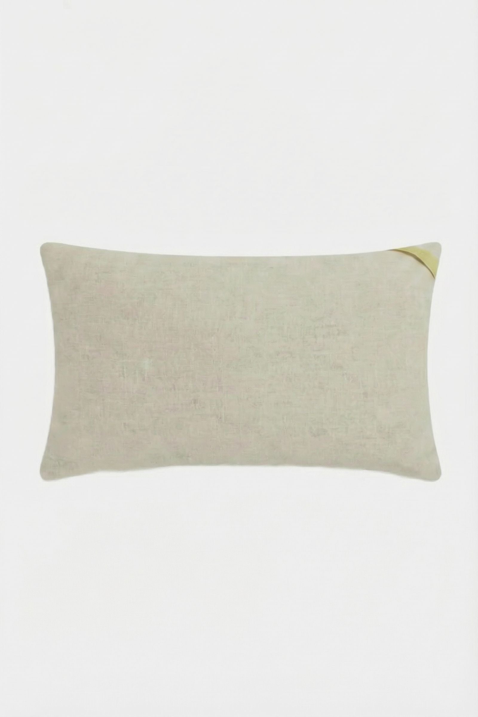The Amazing Maze Embroidered Pillow is a rectangular, light beige cushion with a subtle texture and a small golden ribbon on one corner, displayed against a white background.
