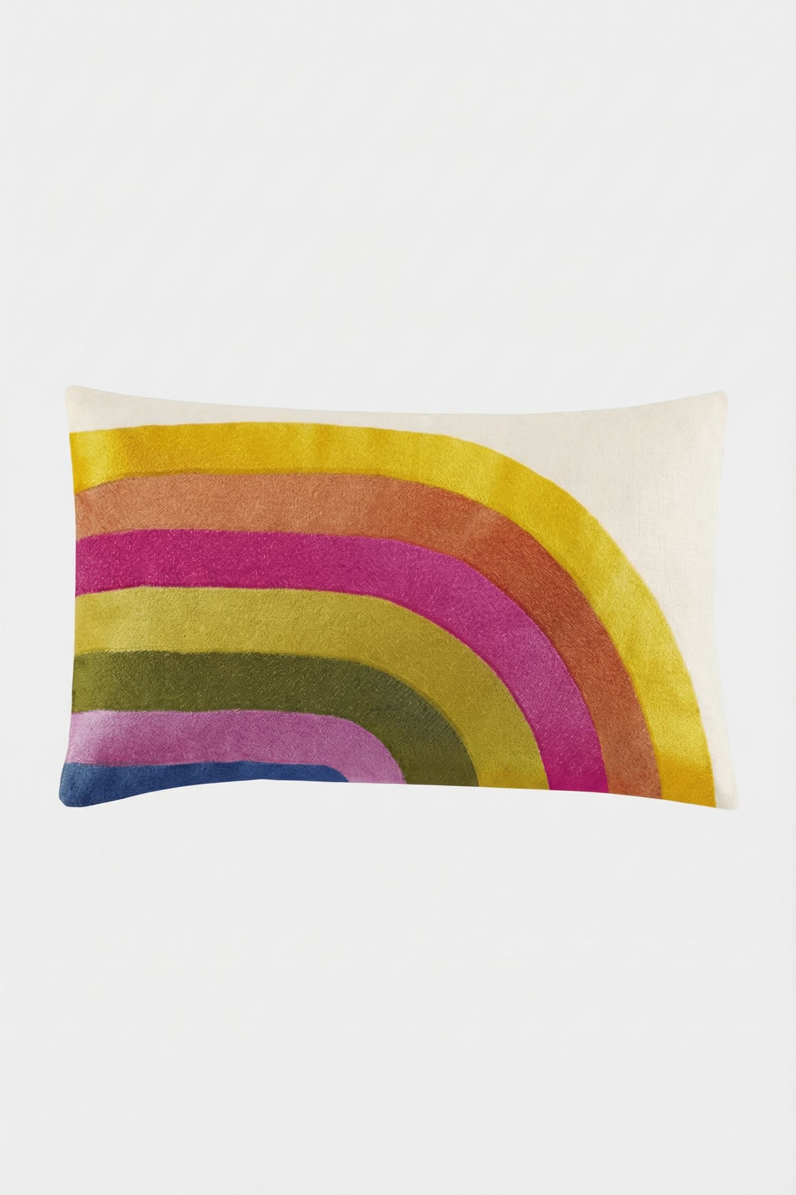 The Calistoga Embroidered Rainbow Lumbar Pillow features colorful embroidery in a curved rainbow—yellow, orange, pink, red, green, and blue—on a cream background, creating a vibrant accent for any space.