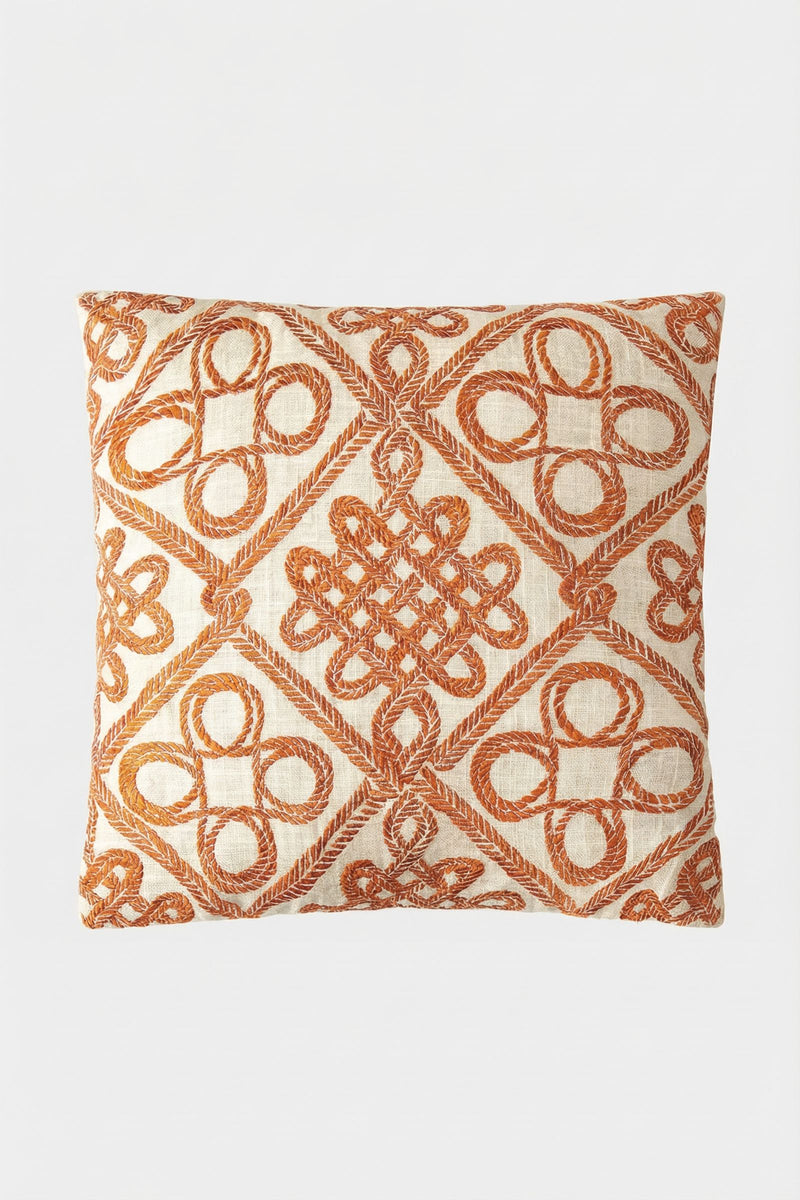 The Costa Mesa Embroidered Square Pillow features a cream background with intricate rust-orange geometric and looped embroidered designs.