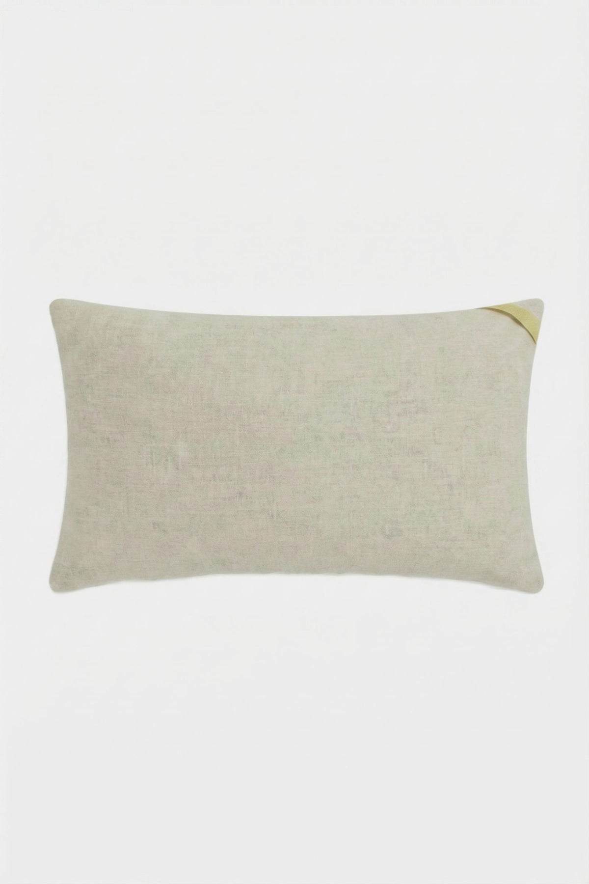 The Escondido Embroidered Lumbar Pillow is rectangular and beige, featuring a subtle textured fabric and a small diagonal gold accent on one corner, shown against a plain white background.
