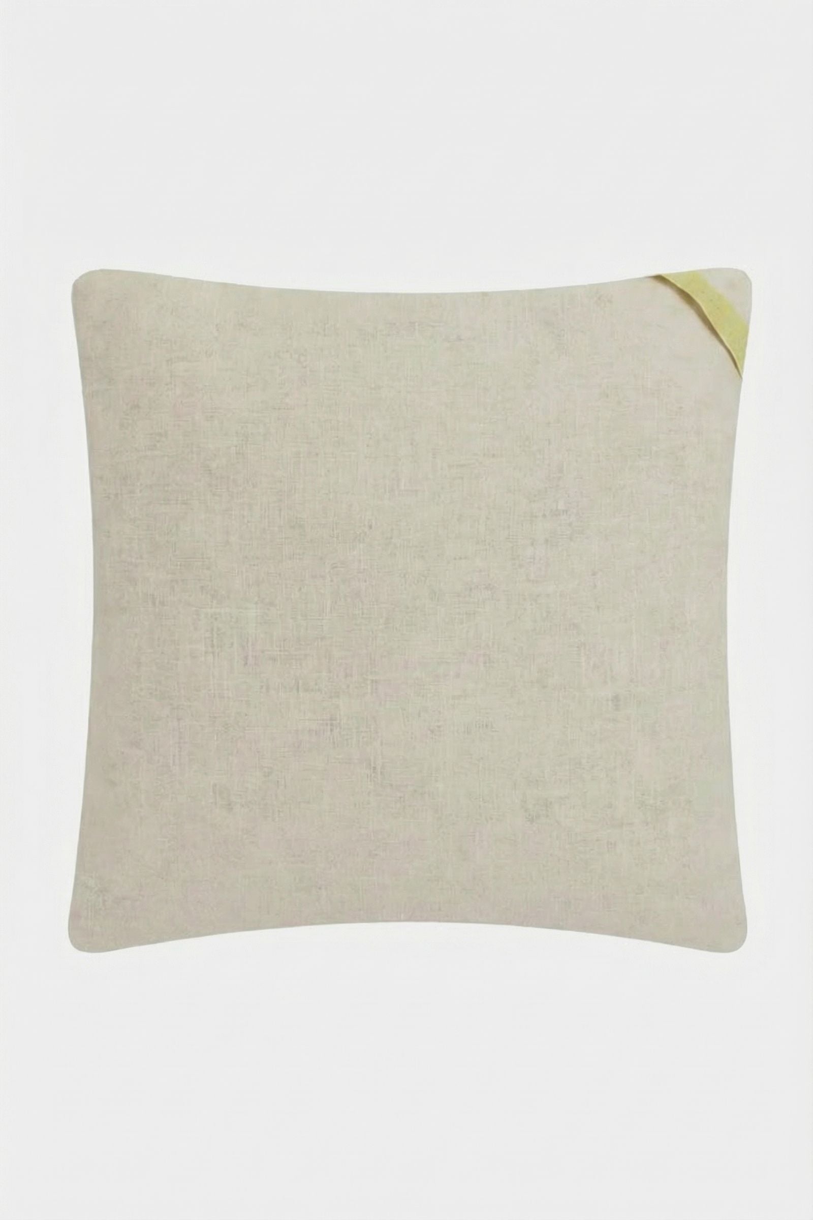 The Monterey Embroidered Throw Pillow is rectangular and beige with a subtle fabric texture. A small yellow fabric tag is on the top right corner. The pillow is set against a white background.