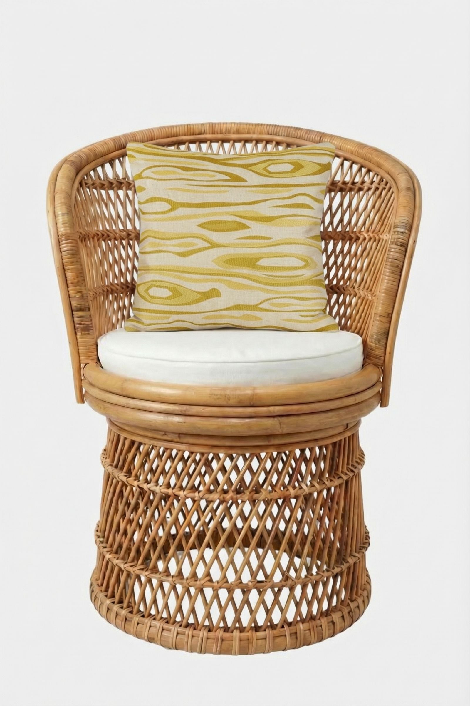 A round wicker chair with an open-weave design, white seat cushion, and the Monterey Embroidered Throw Pillow—featuring a yellow and beige geometric pattern—set against a plain white background.
